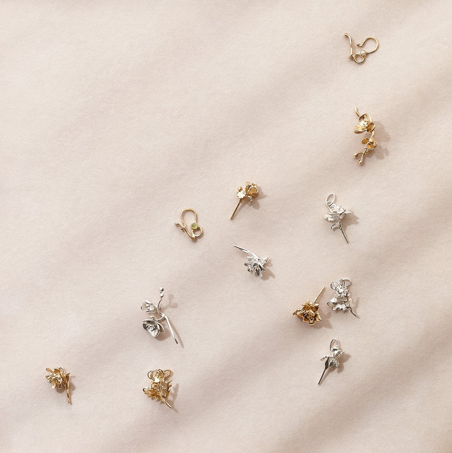 Various floral charms on a light pink fabric background