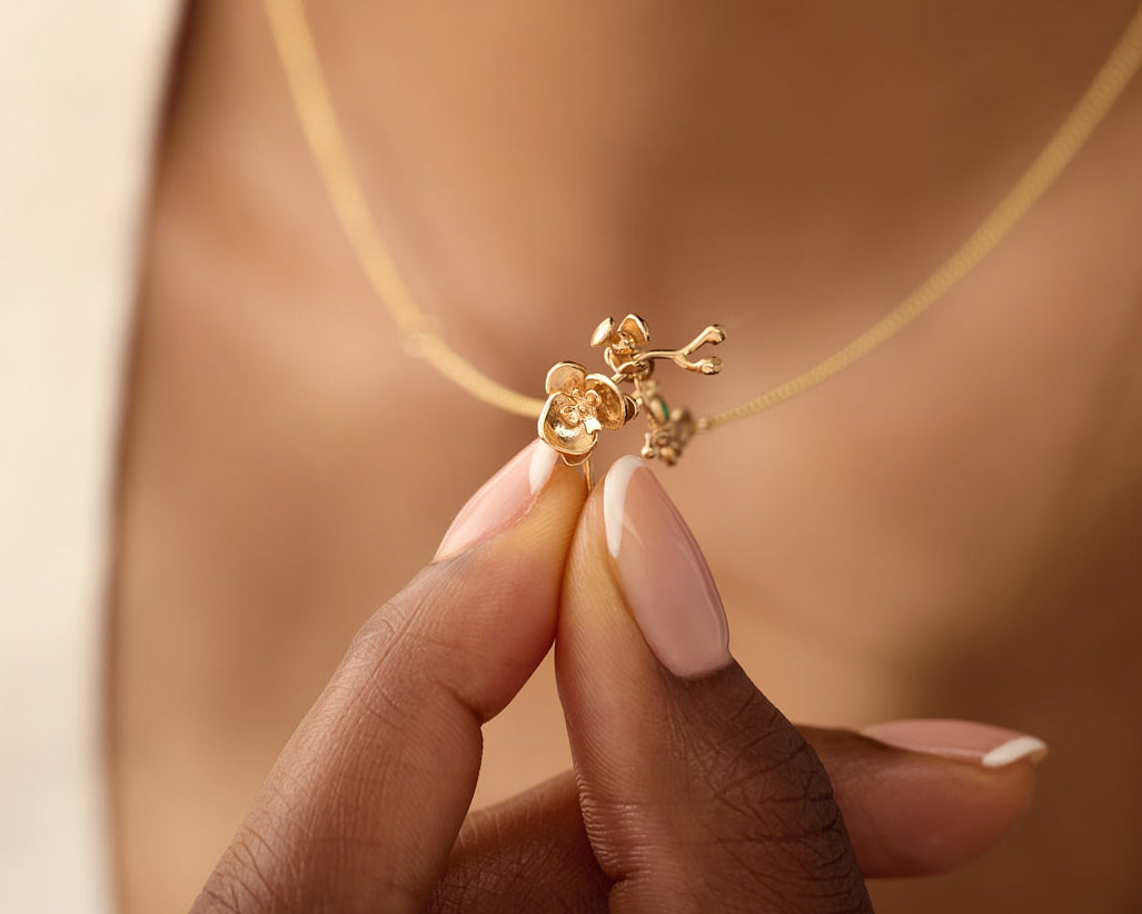 Woman holding orchid charm pendant