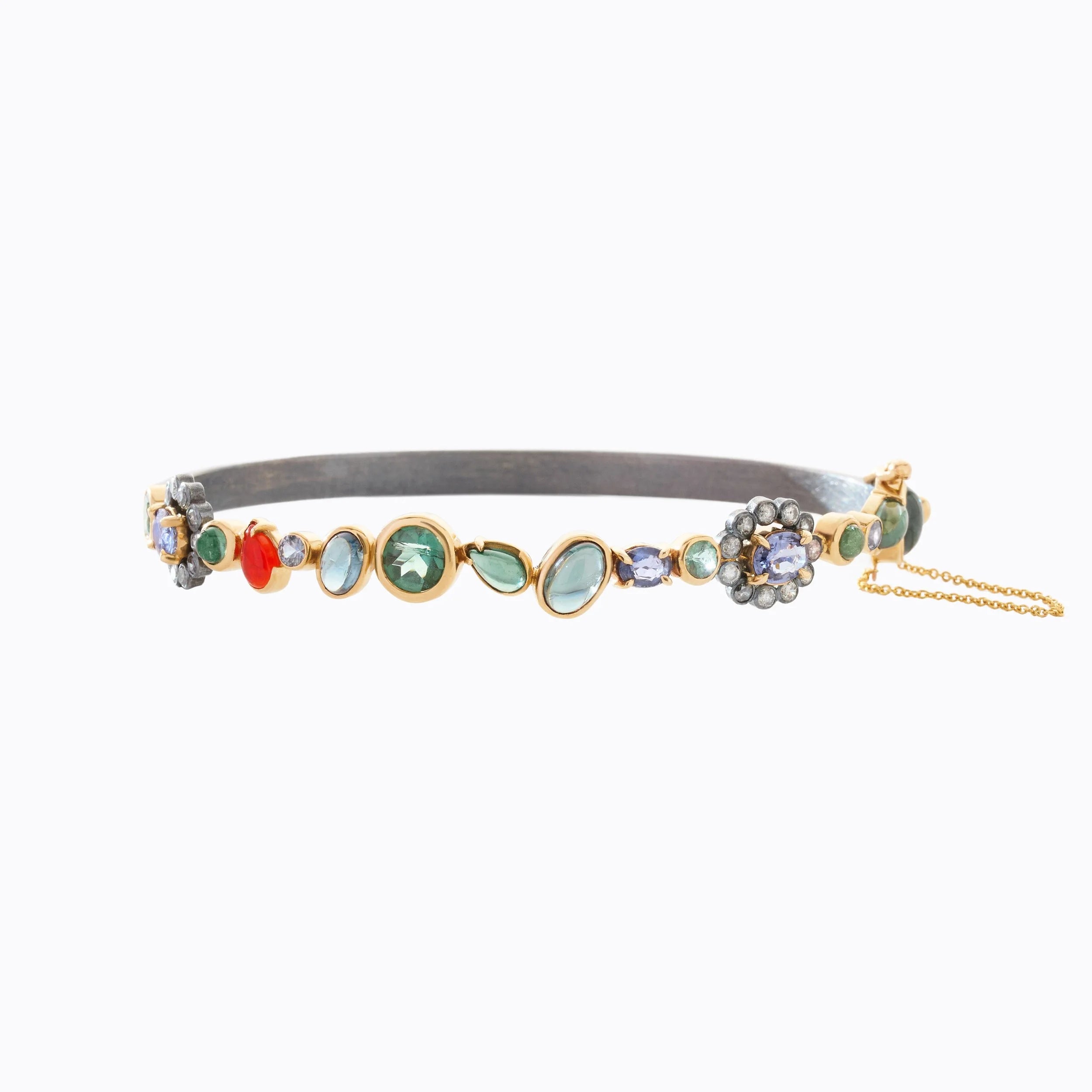 Decorative gold cuff with colorful gemstones on a white background