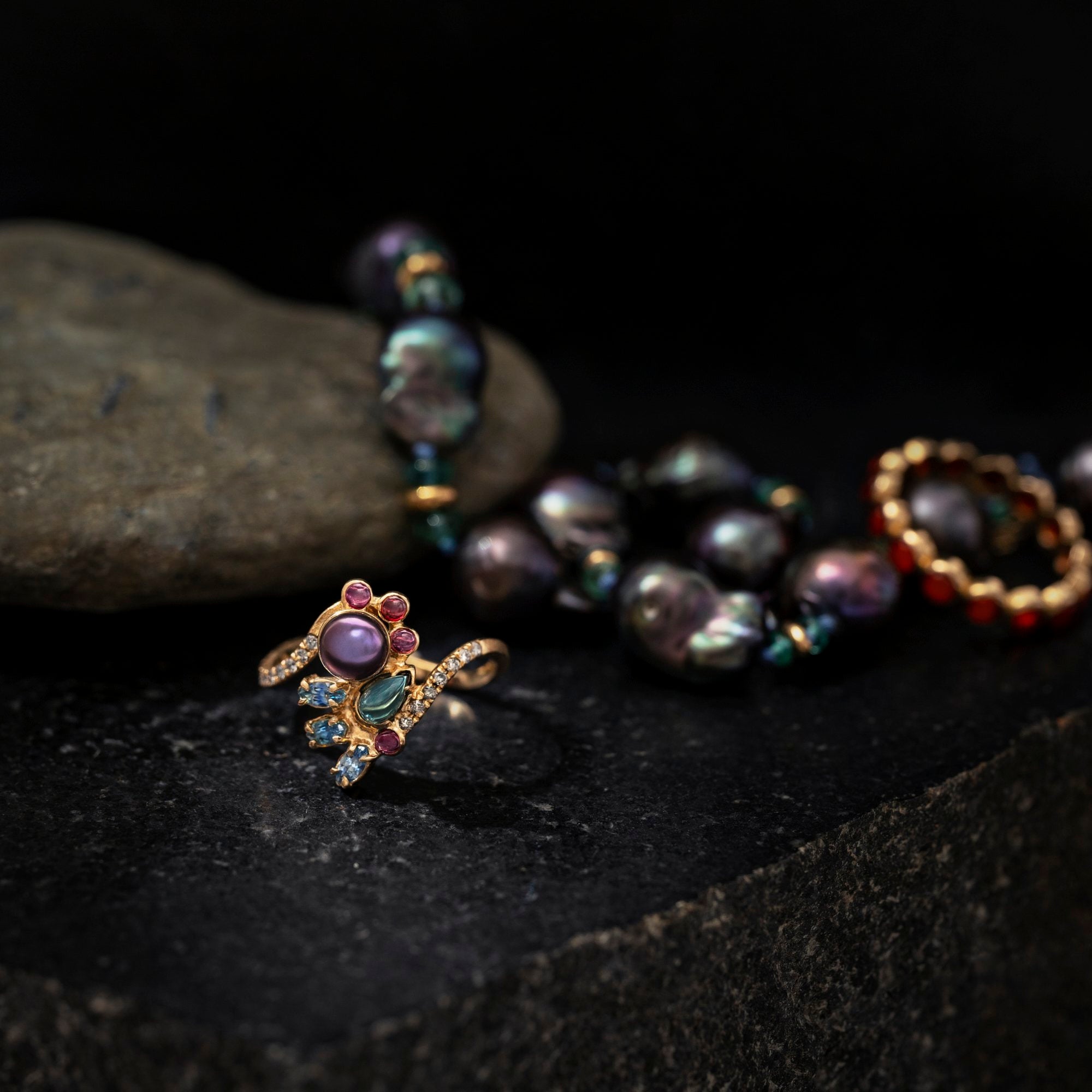 Gold ring with gemstones on a dark surface
