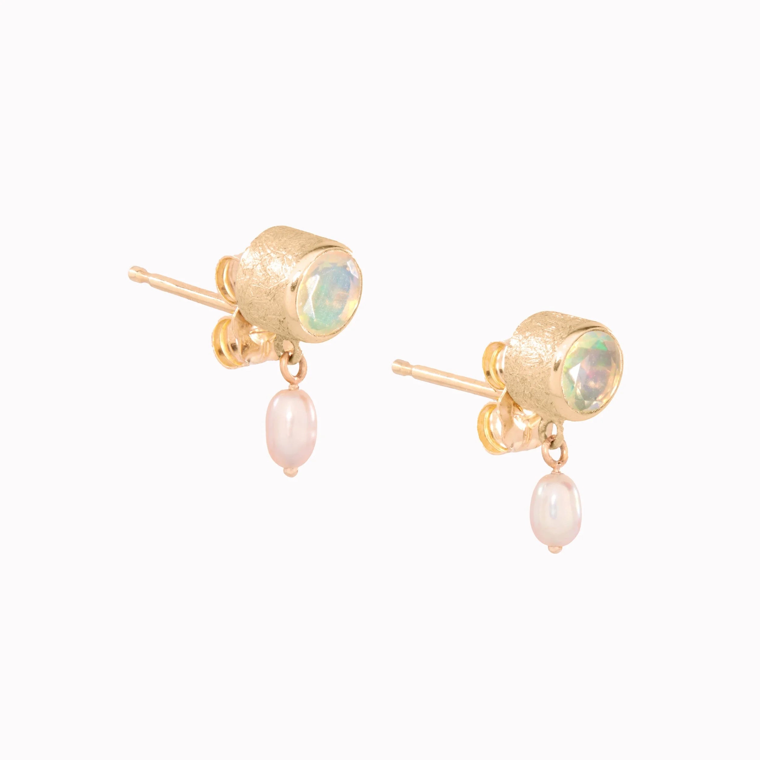 Gold earrings with gemstones and pearls on a white background