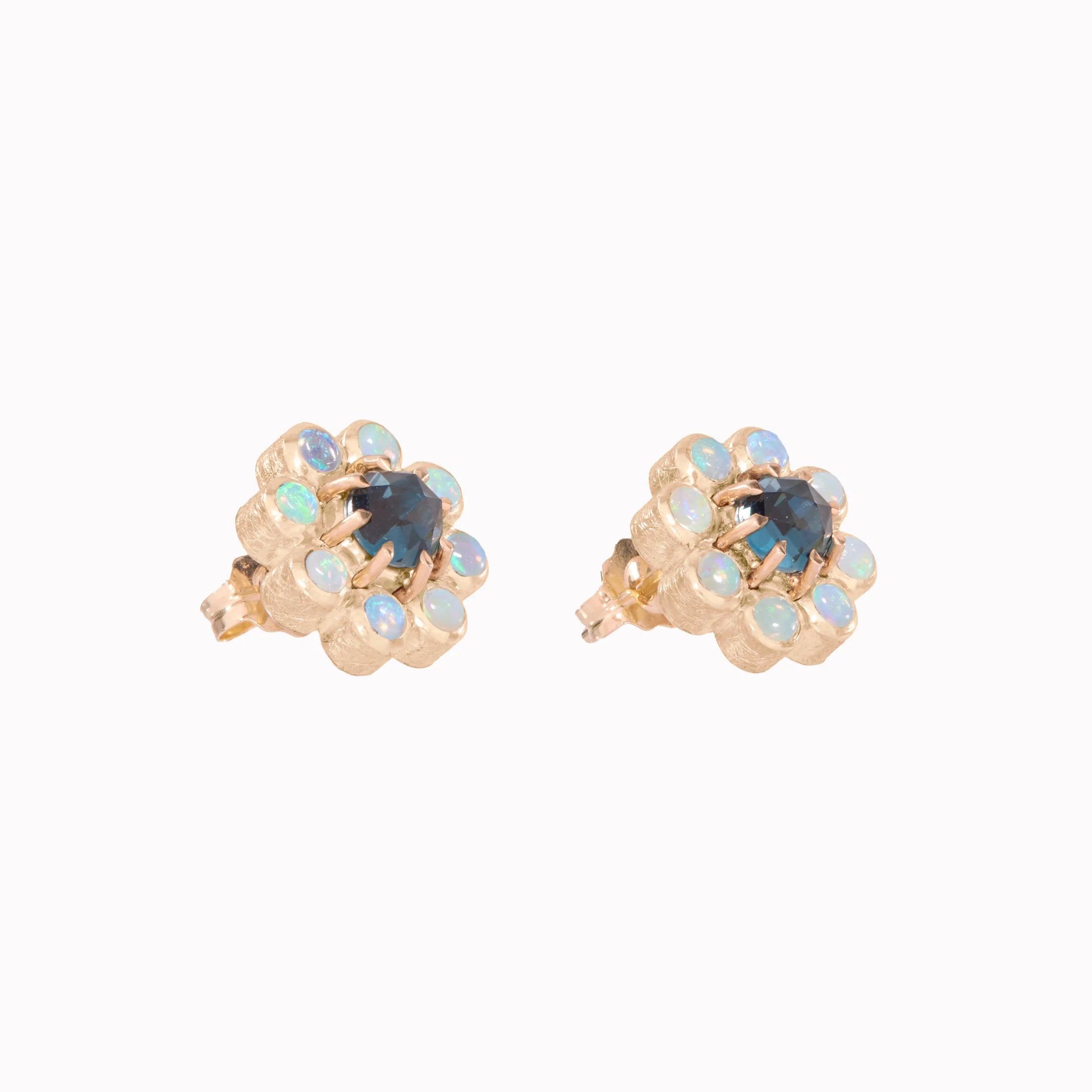Pair of gold earrings with blue gemstones on a white background