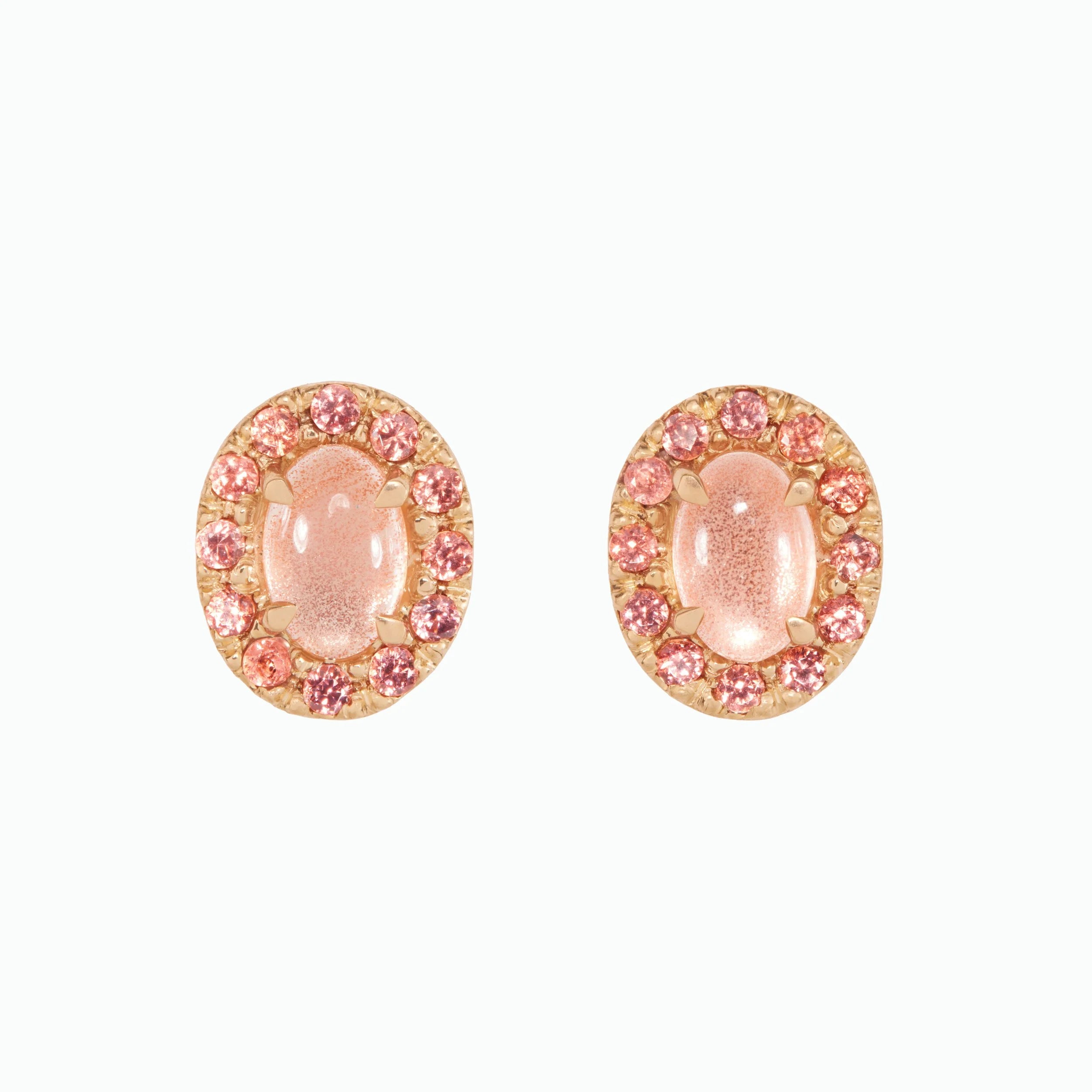 Pair of pink oval earrings with small stones on a white background