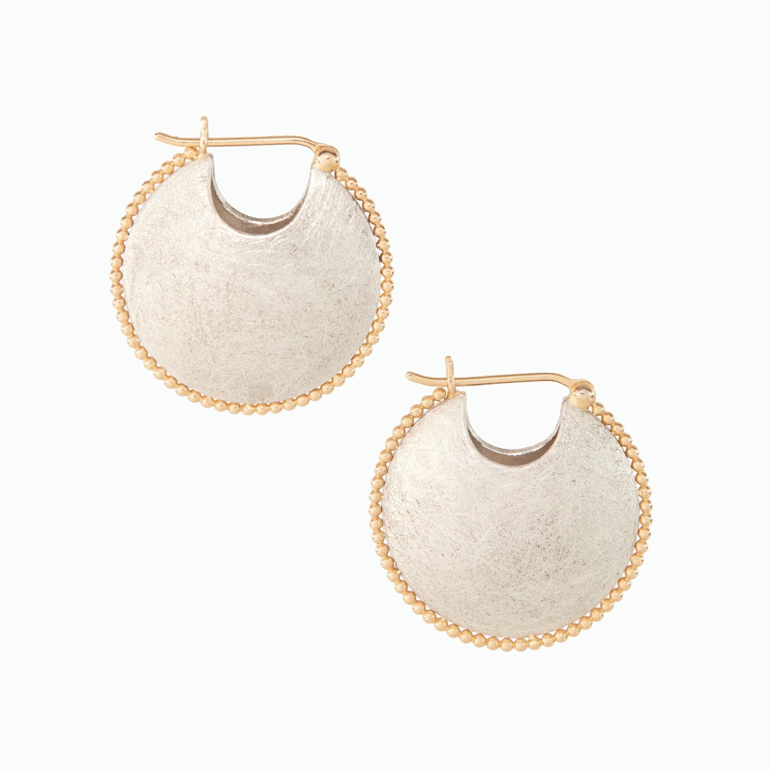 Pair of silver hoop earrings with gold accents on a white background
