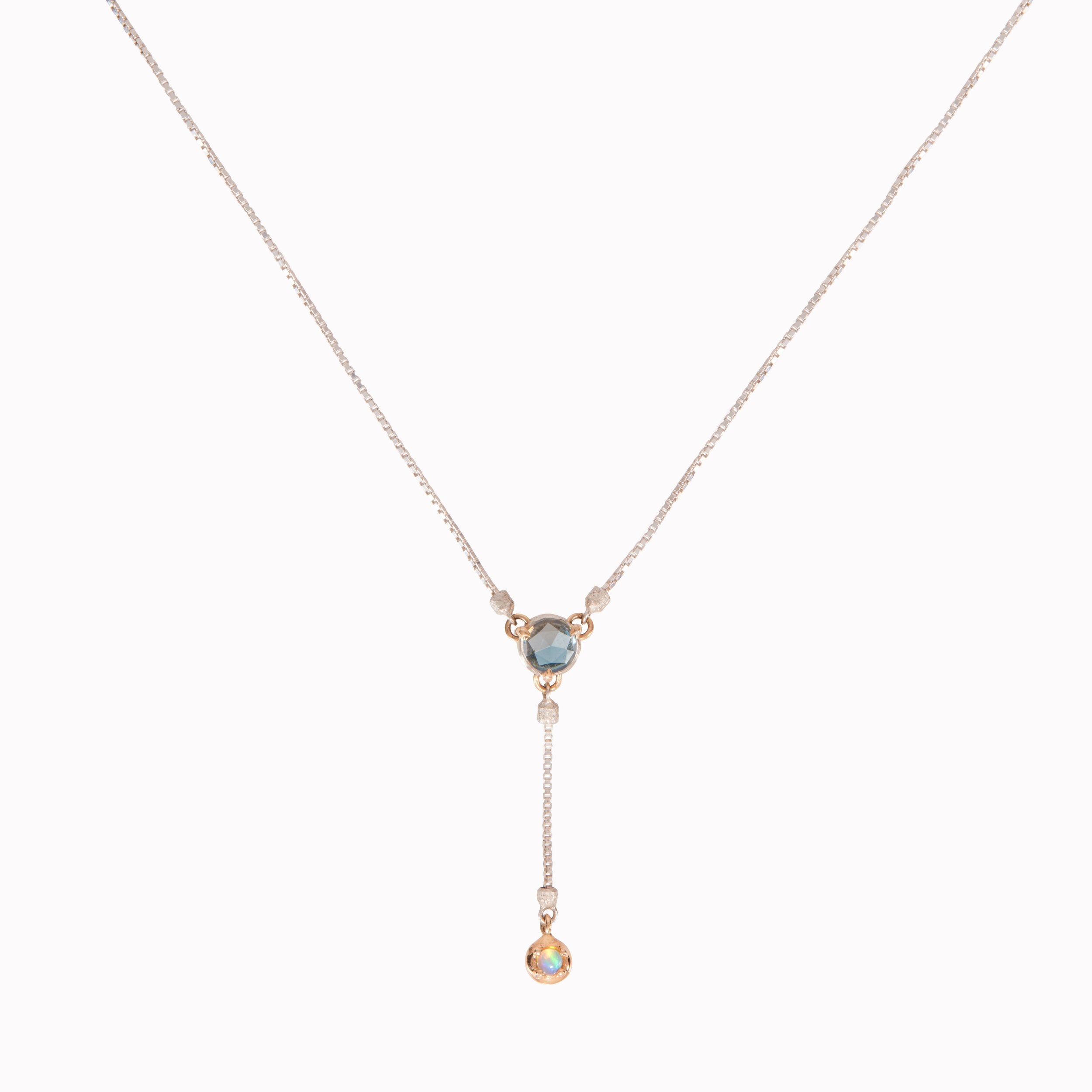 Necklace with a triangular pendant and hanging droplet on a white background