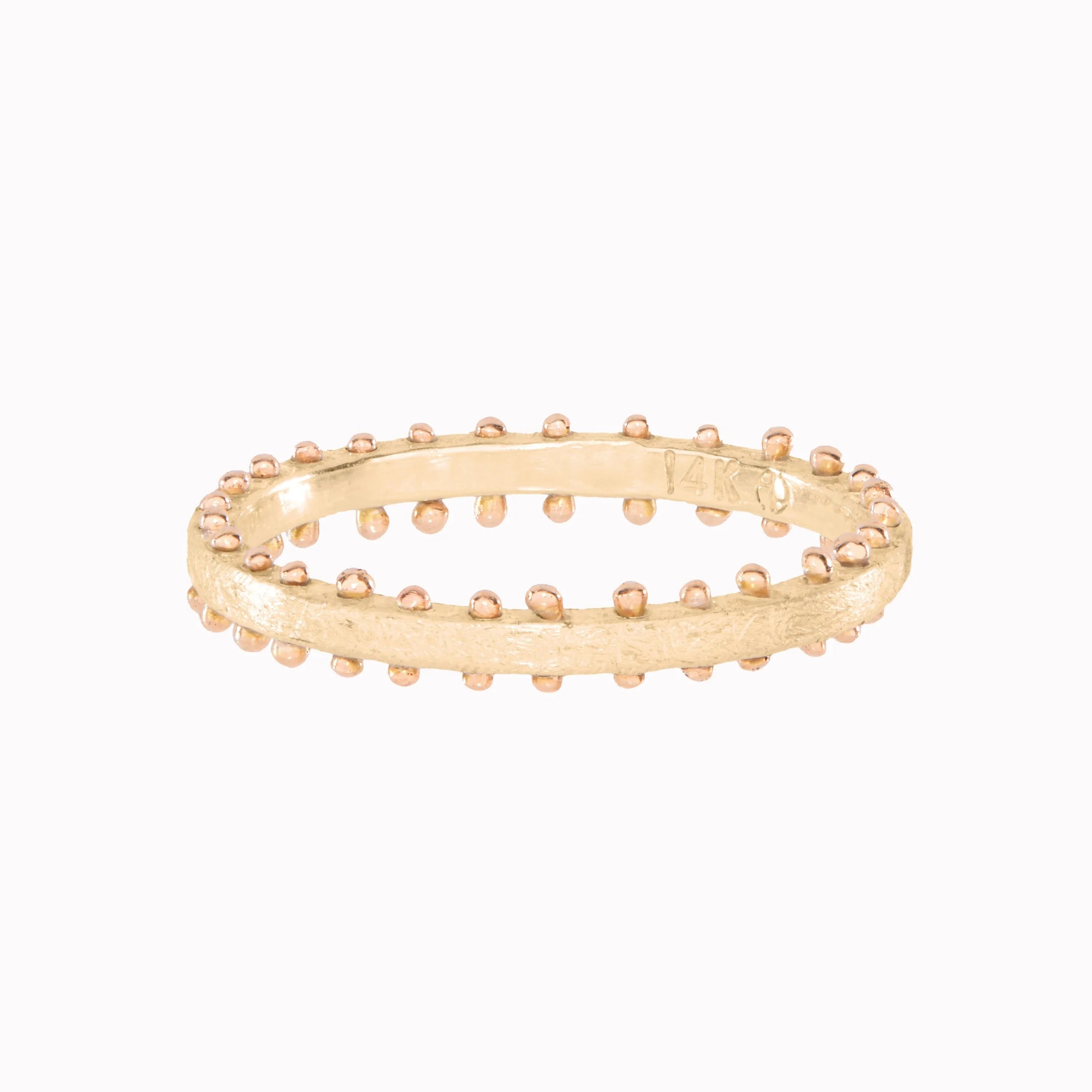 Gold ring with textured design on a white background