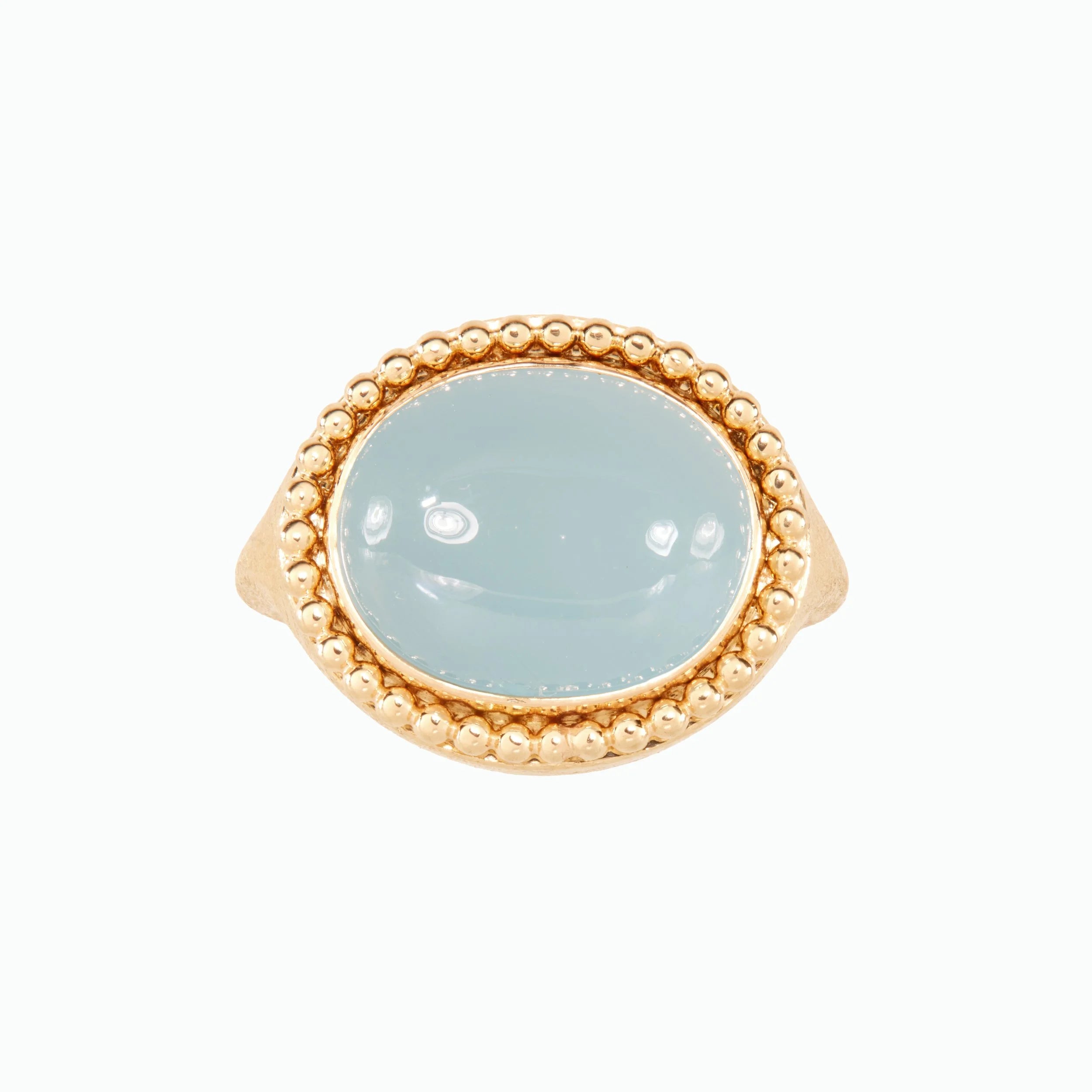Ring with gold band and light blue stone on a white background
