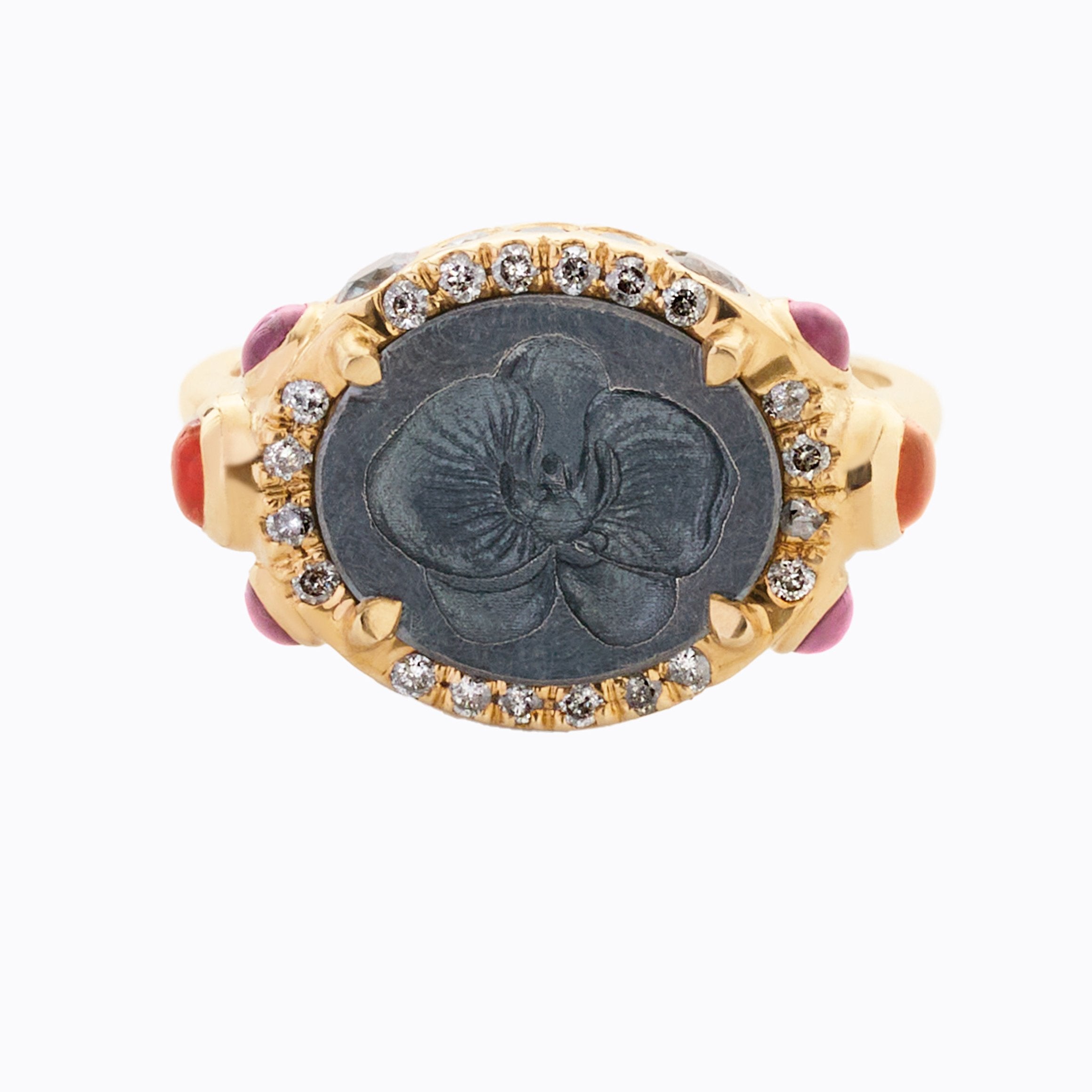 Gold ring with black center and gemstones on a white background
