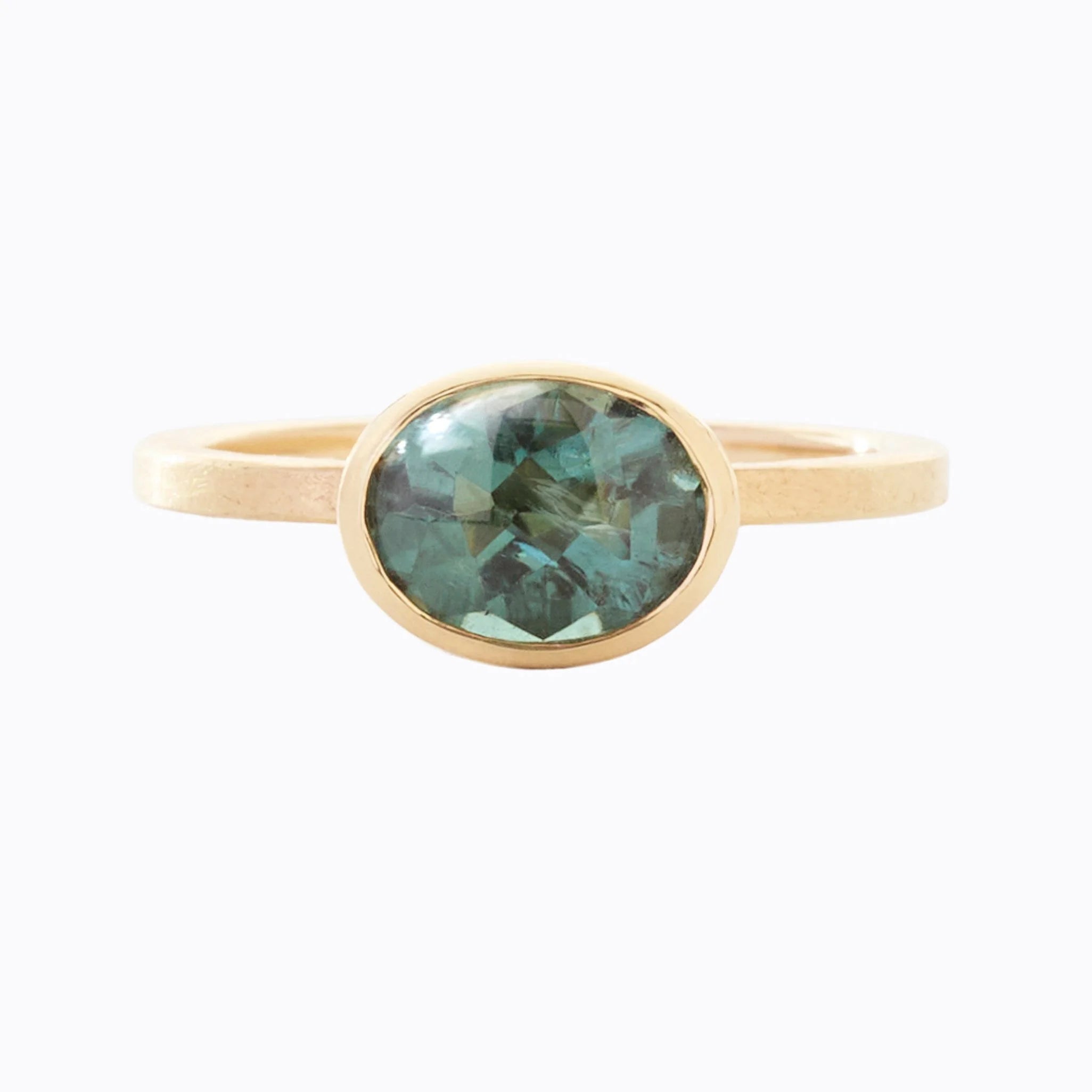 Gold ring with a teal gemstone on a white background