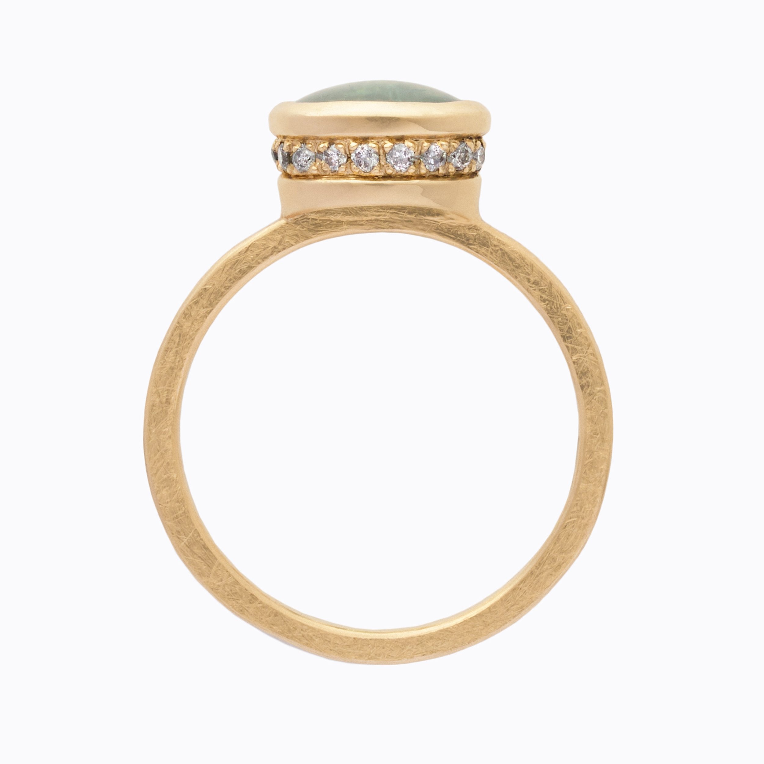 Gold ring with a teal stone and diamond accents on a white background
