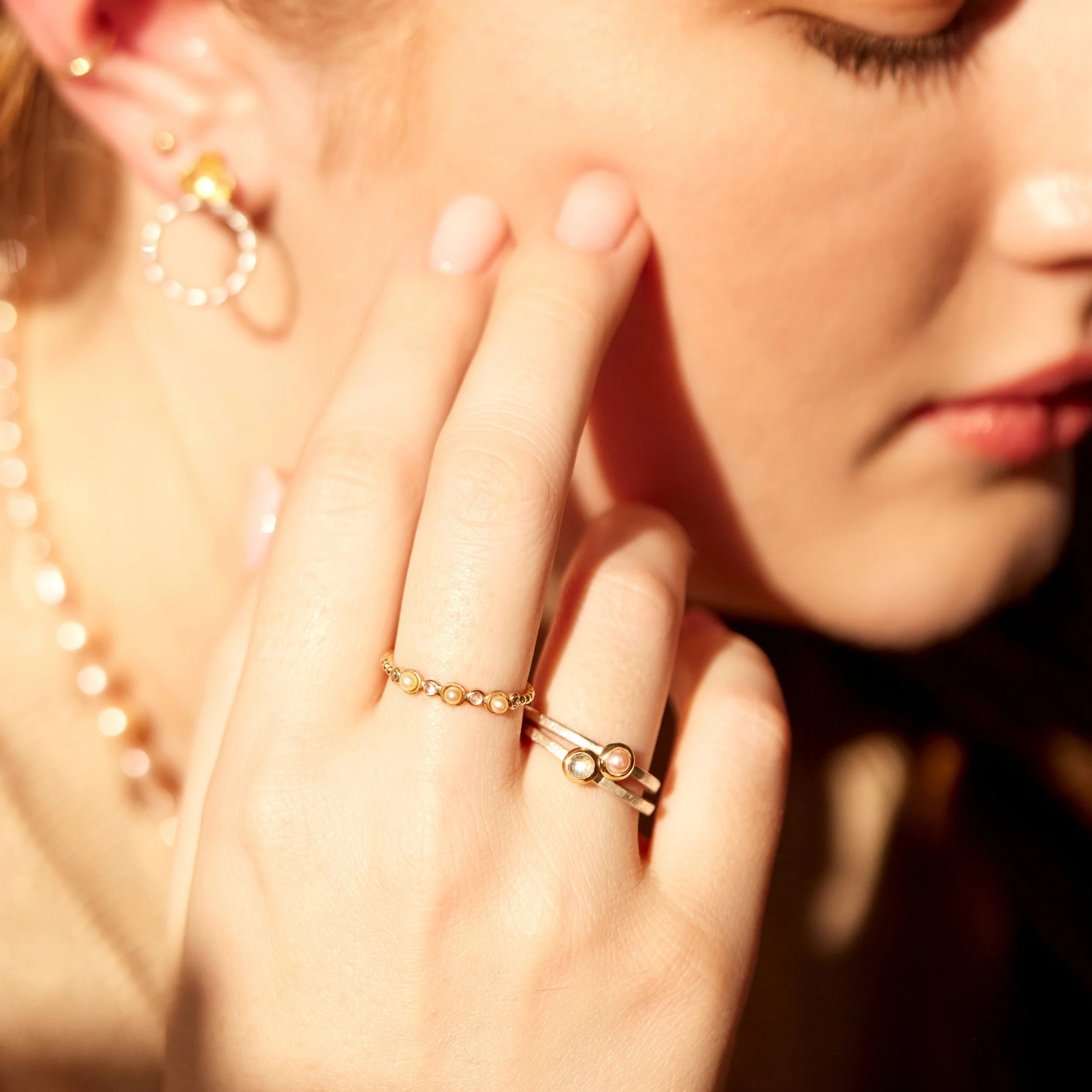 Close-up of a woman's hand wearing a gold ring with a blurred background