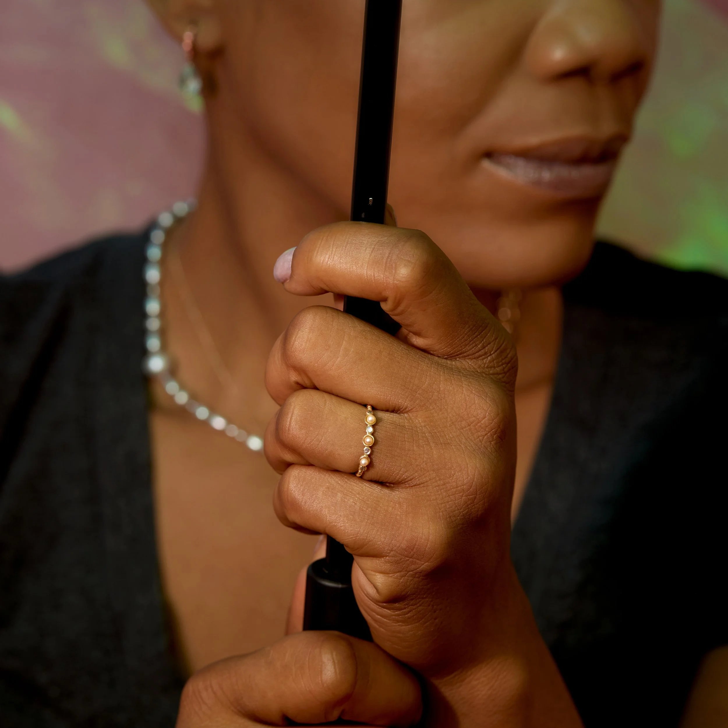 Person holding a black umbrella with a blurred background