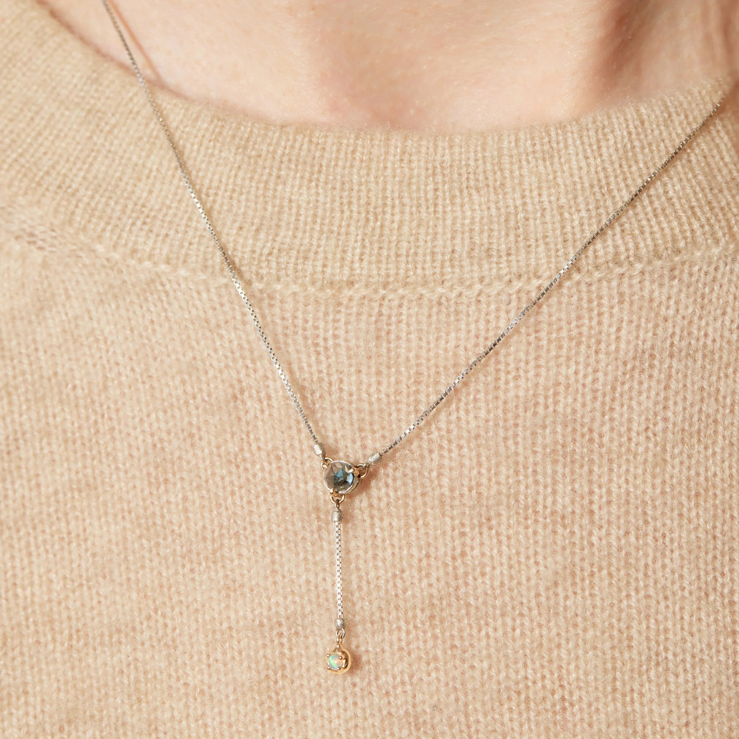 Necklace with a pendant on a beige sweater