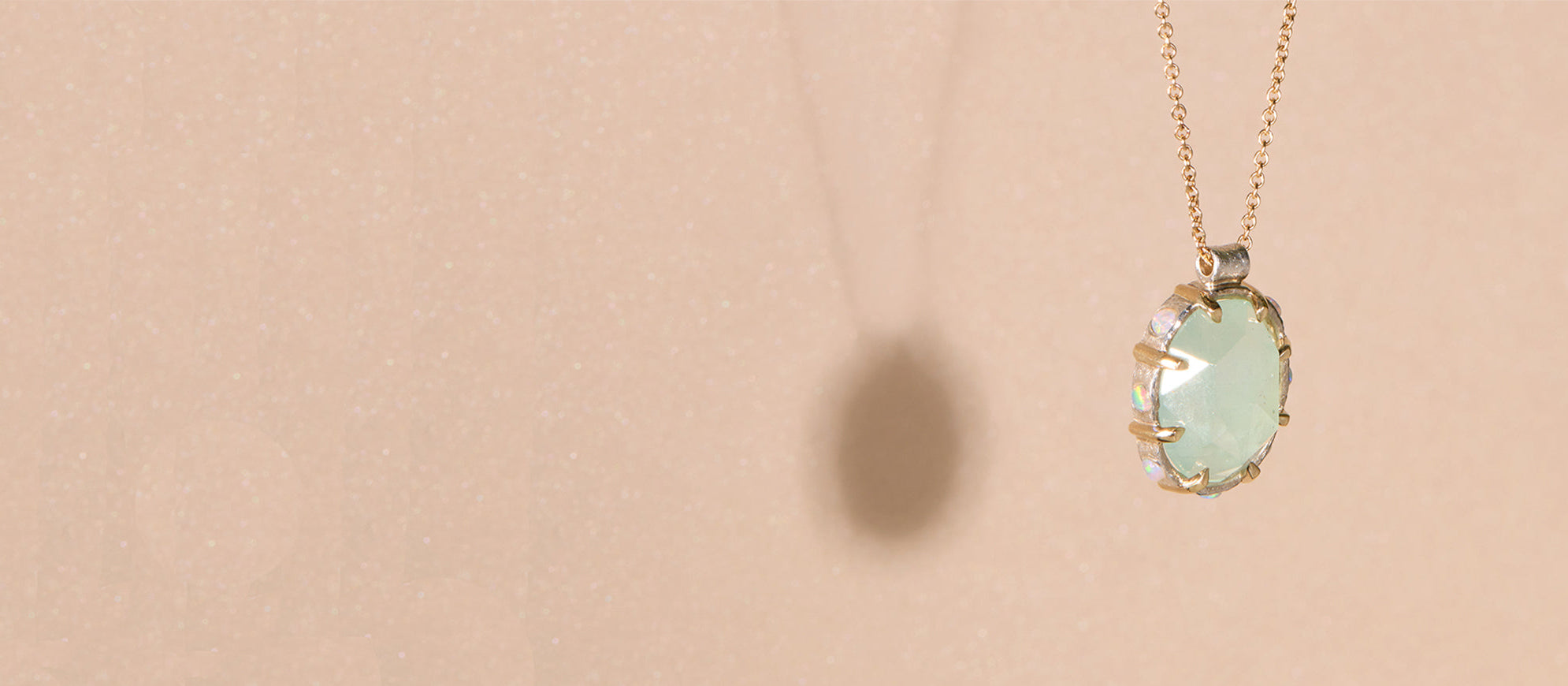 Opal and aquamarine pendant necklace on a beige background
