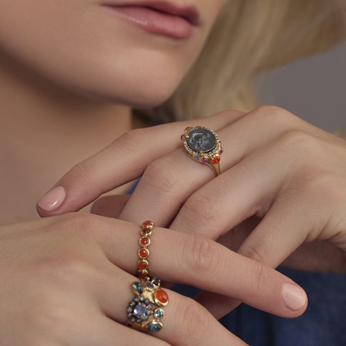 Close-up of a hand wearing ornate rings with gemstones.