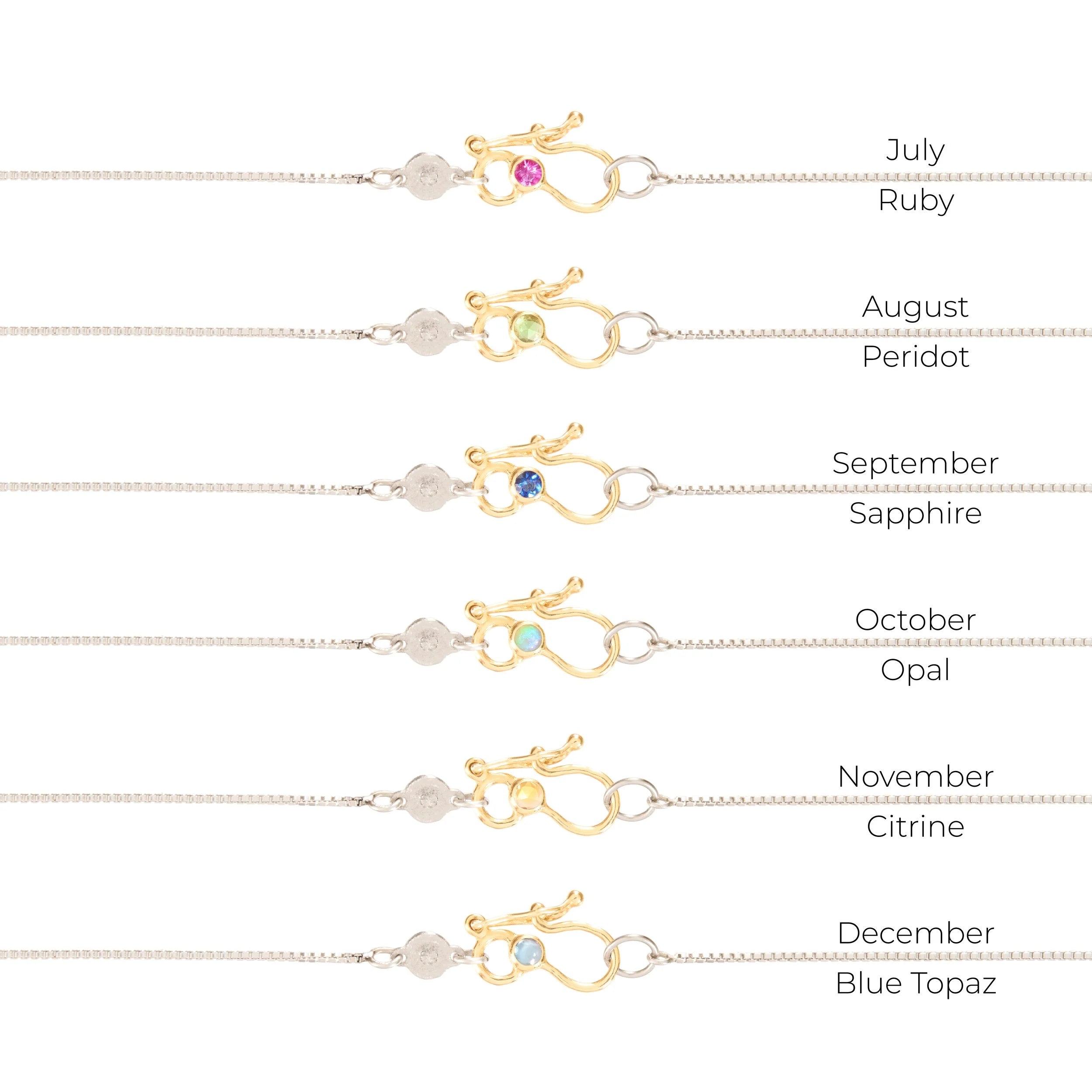 Jewelry display with birthstones for each month on a white background
