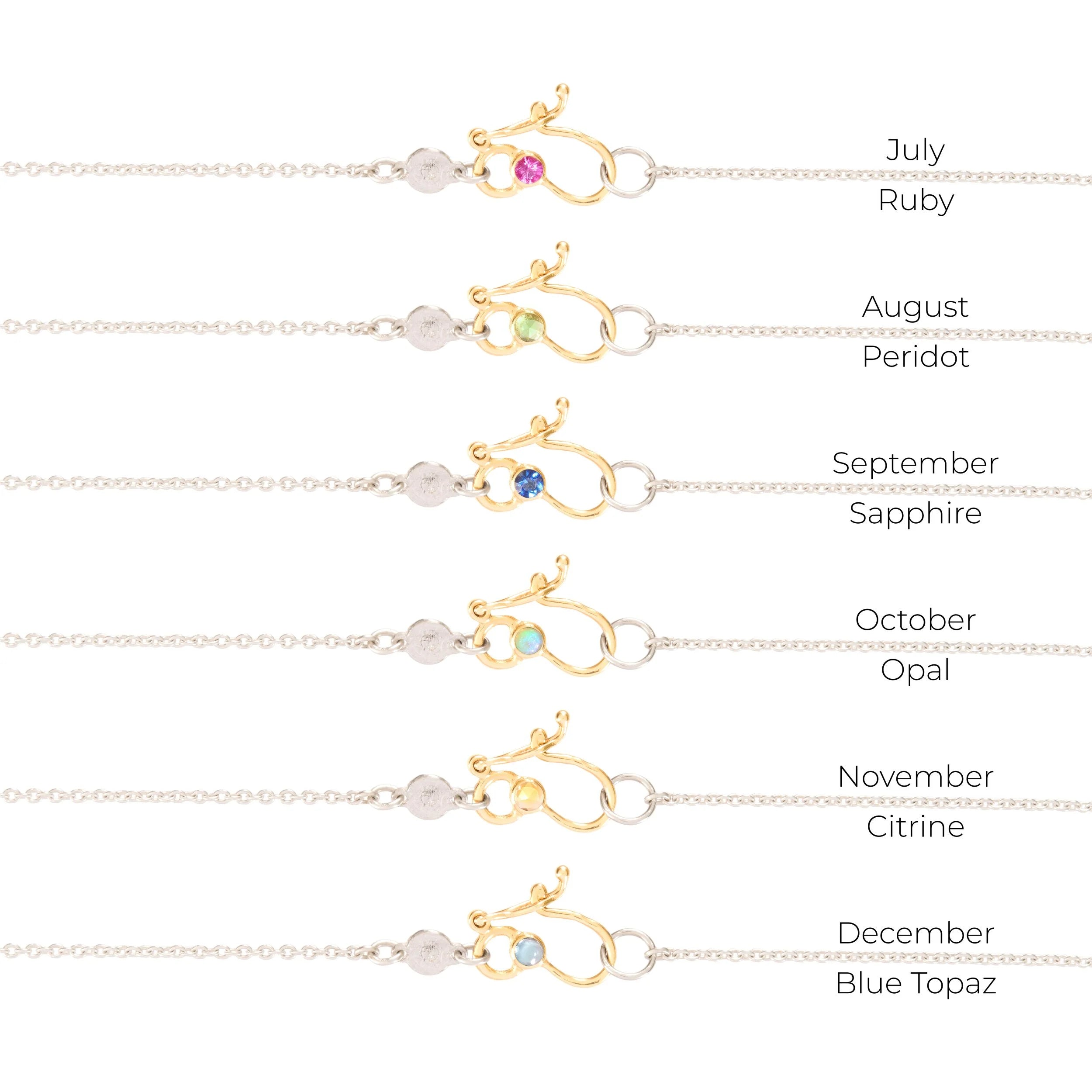Gold necklaces set with gemstones for each month, on a white background.