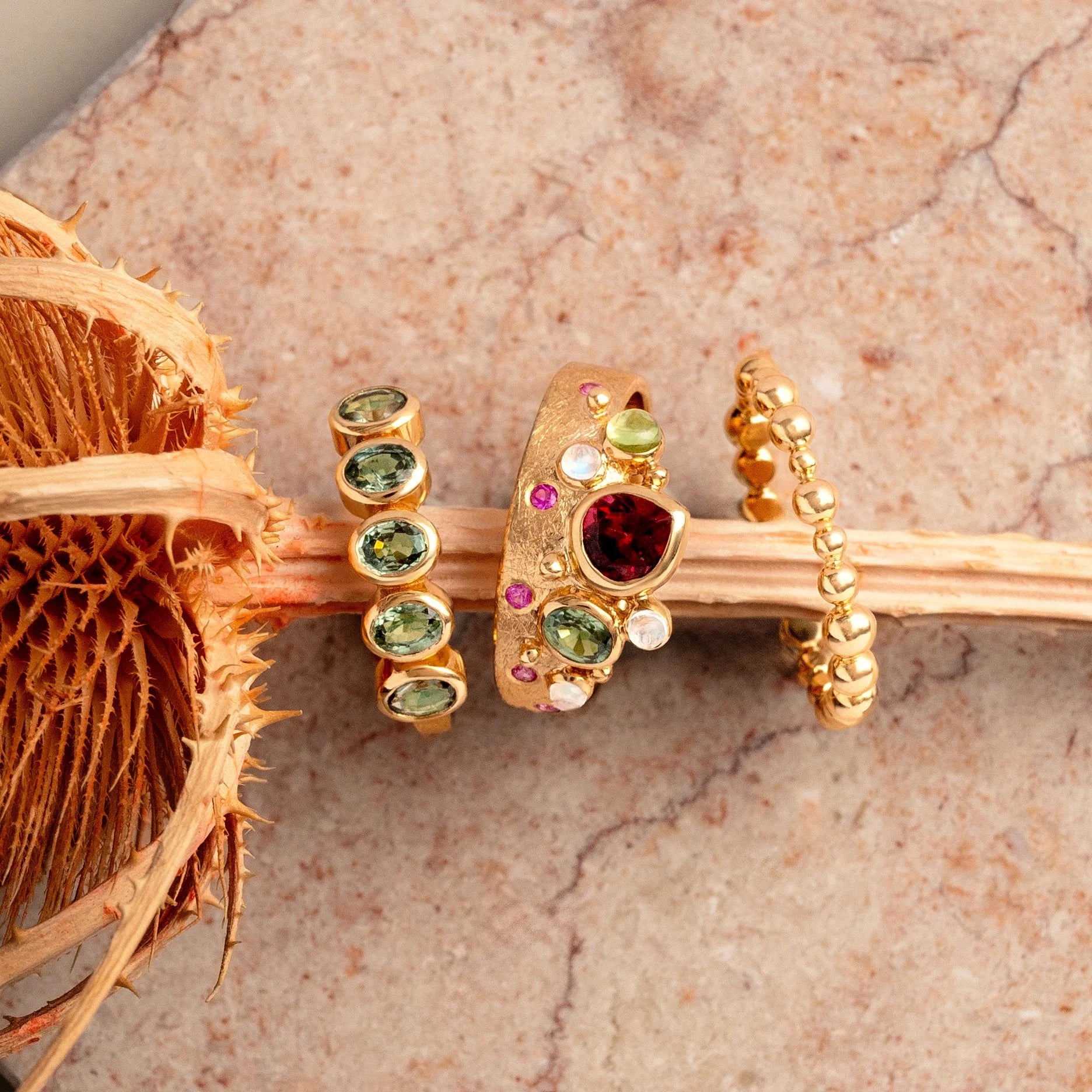 Gold rings with gemstones on a textured surface