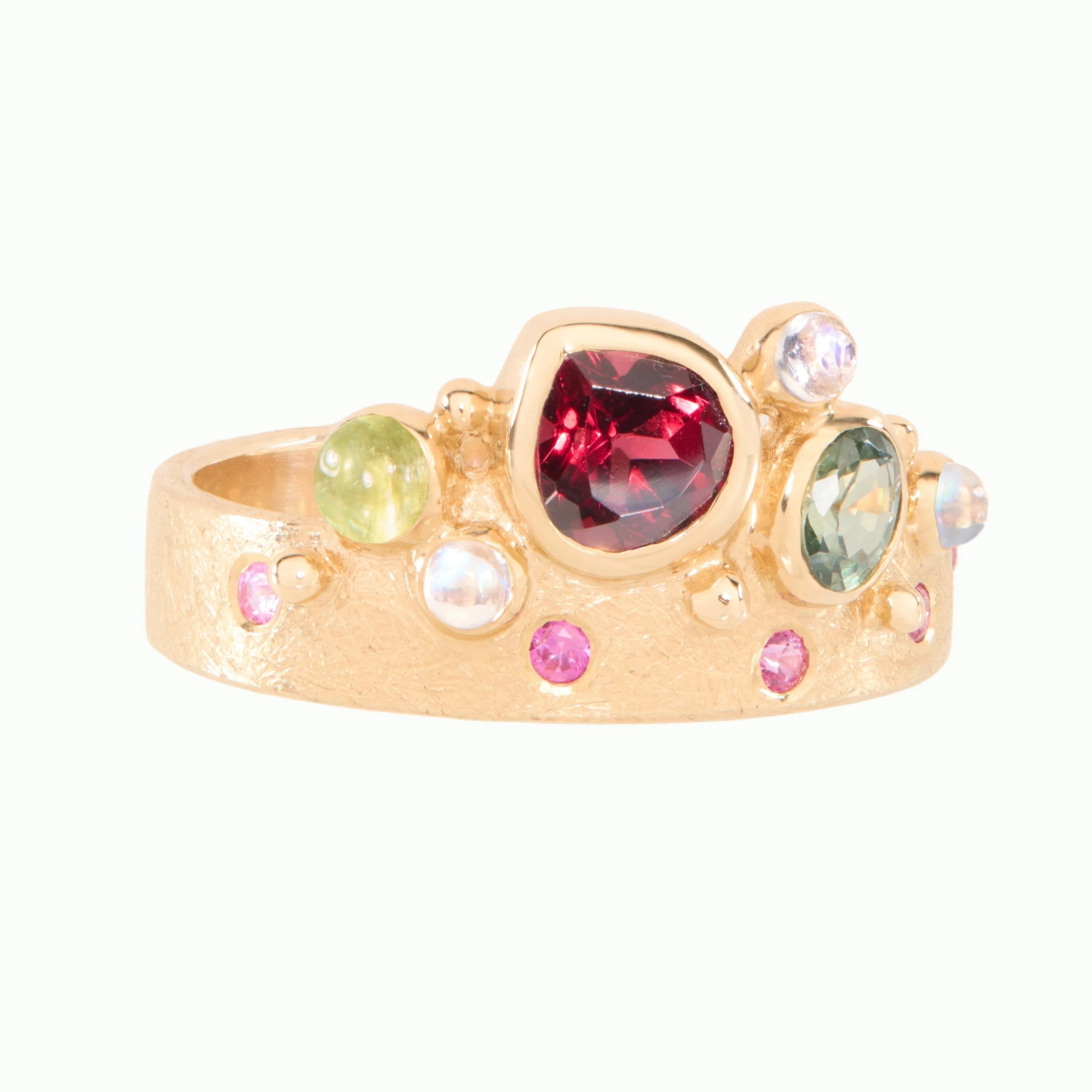 Gold ring with multicolored gemstones on a white background