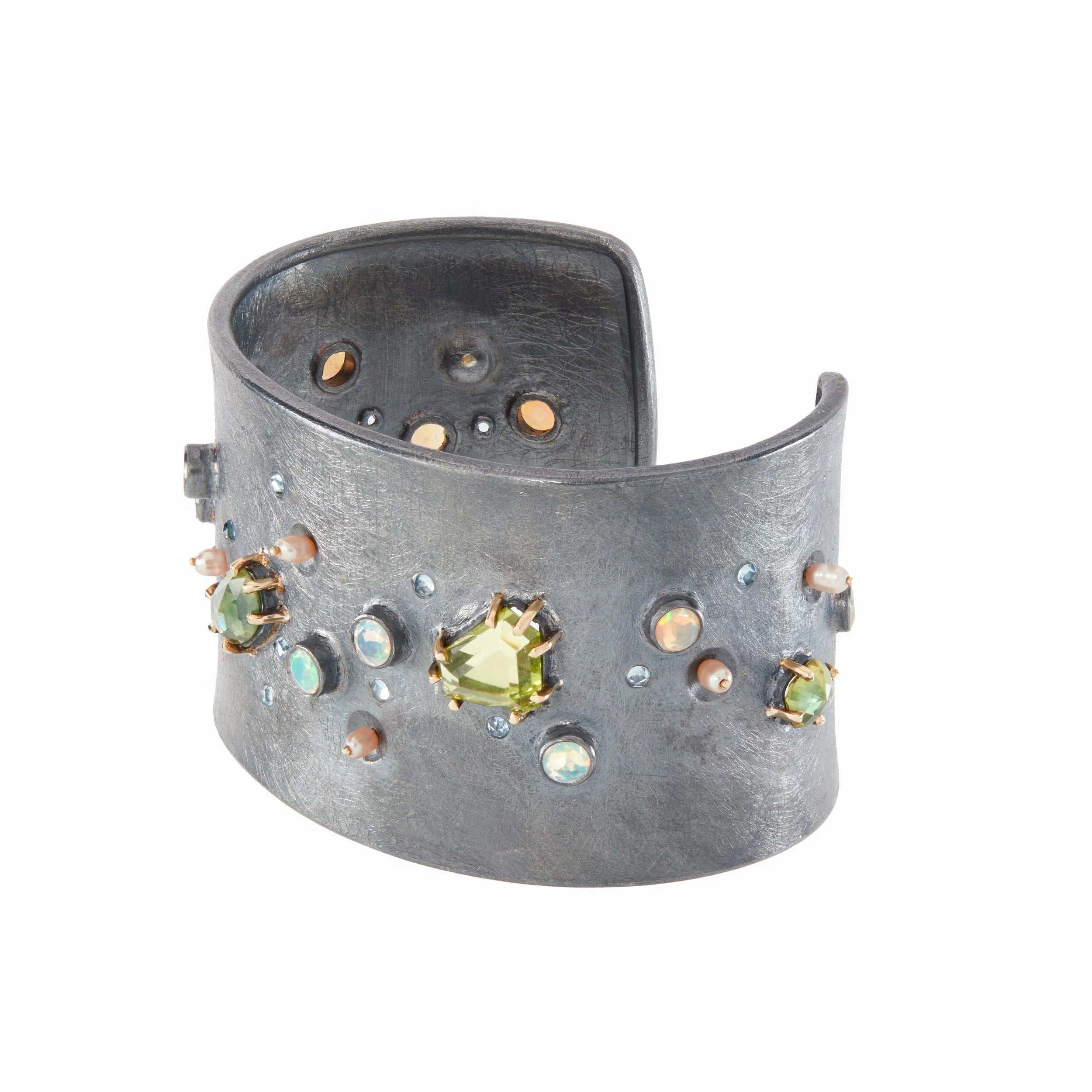 Silver cuff bracelet with embedded gemstones on a white background