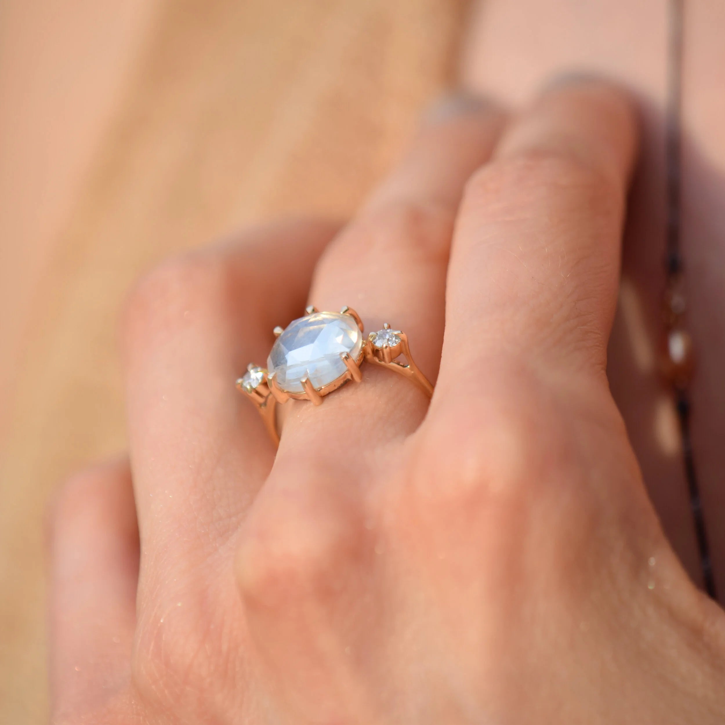 Gold ring with a central gemstone and smaller stones on a blurred background