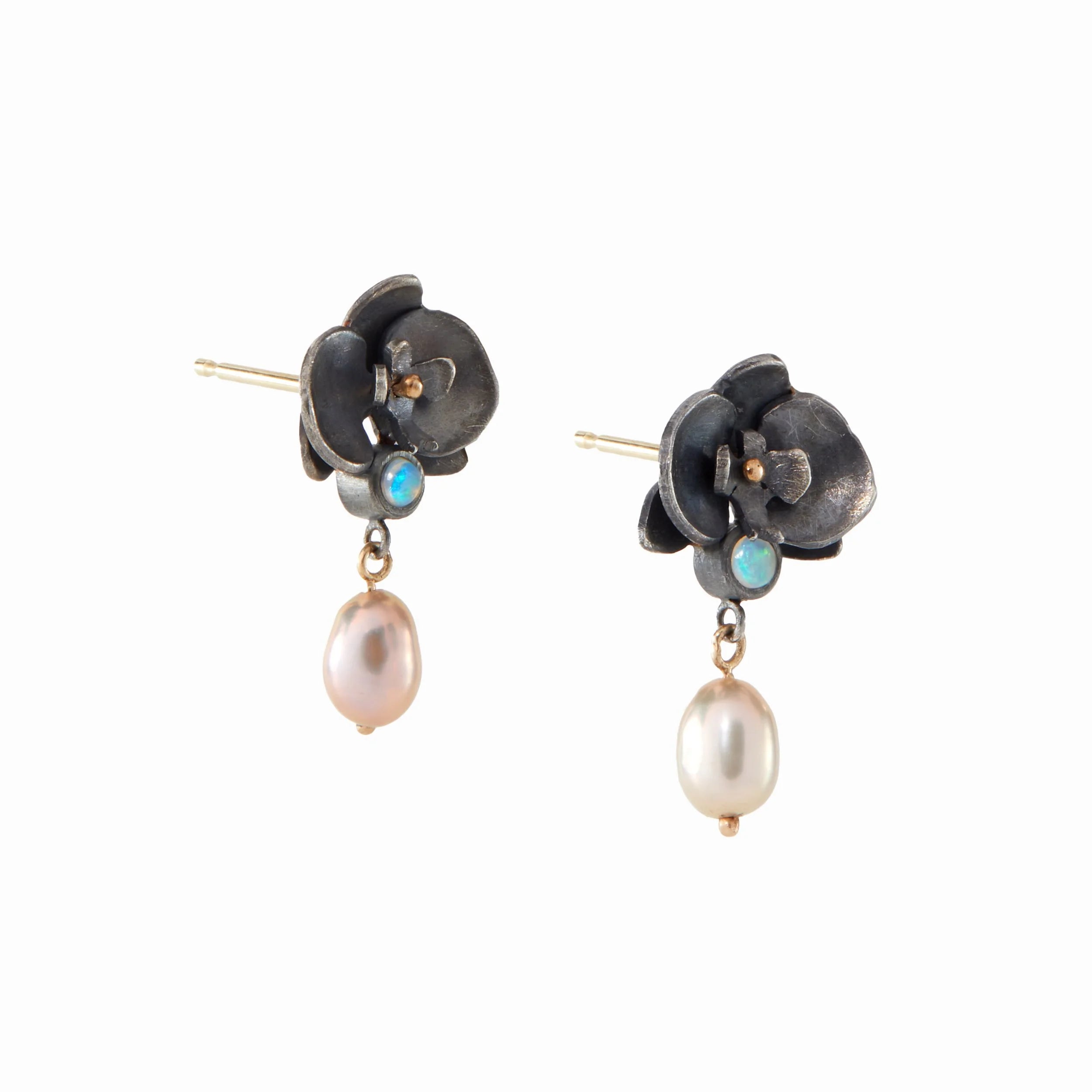 Pair of floral earrings with pearl and opal stones on a white background