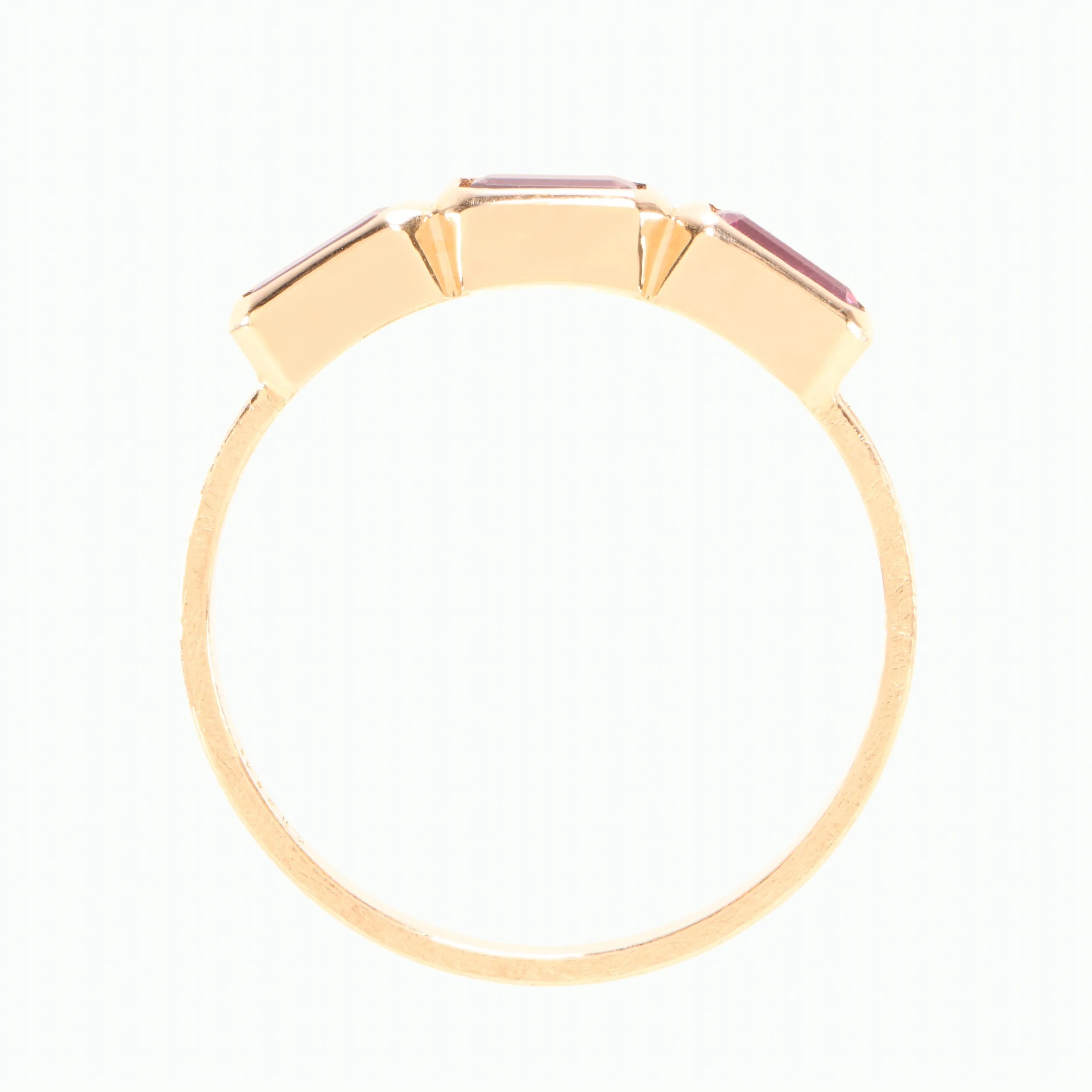 Gold ring with a purple gemstone on a white background