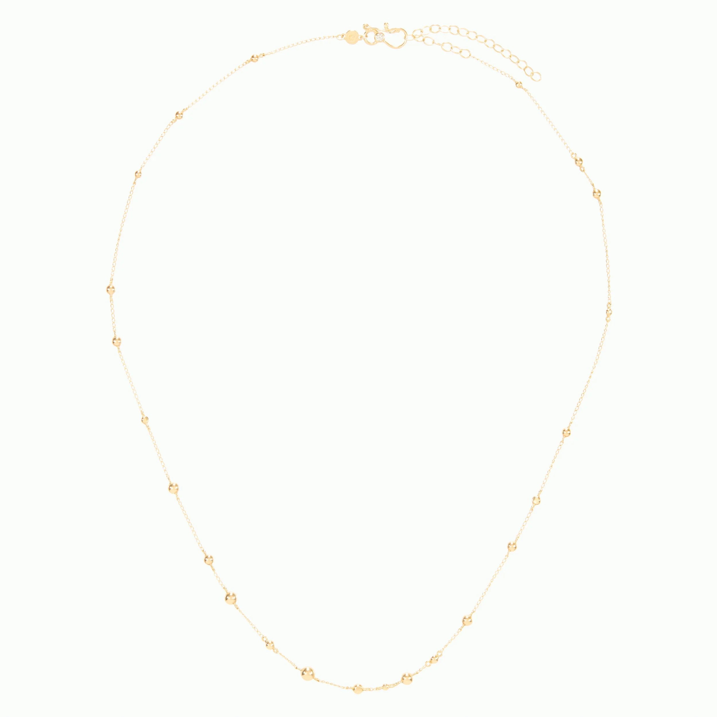Gold necklace with small gold beads on a white background