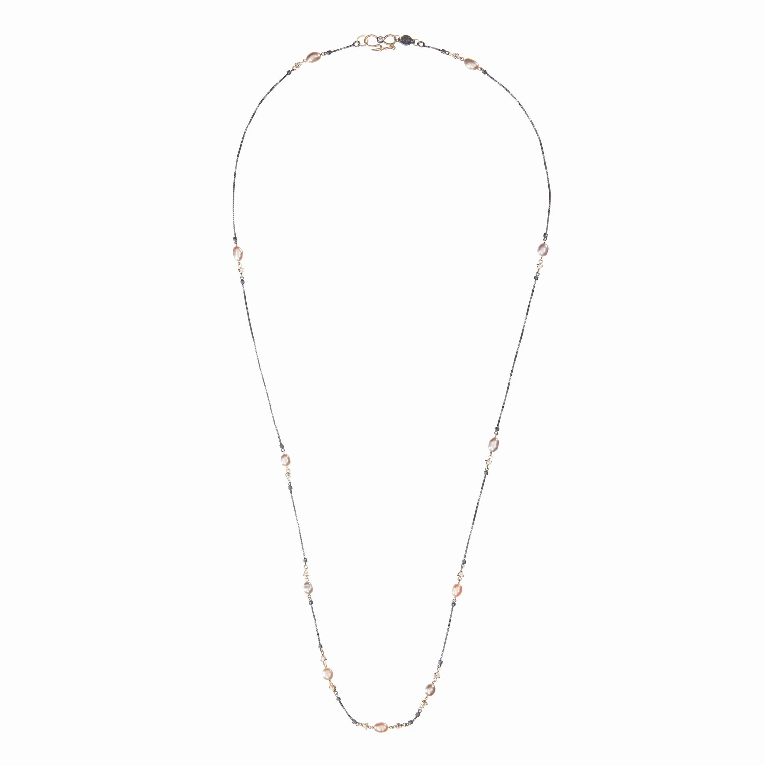 Necklace with small gold and pearl beads on a white background