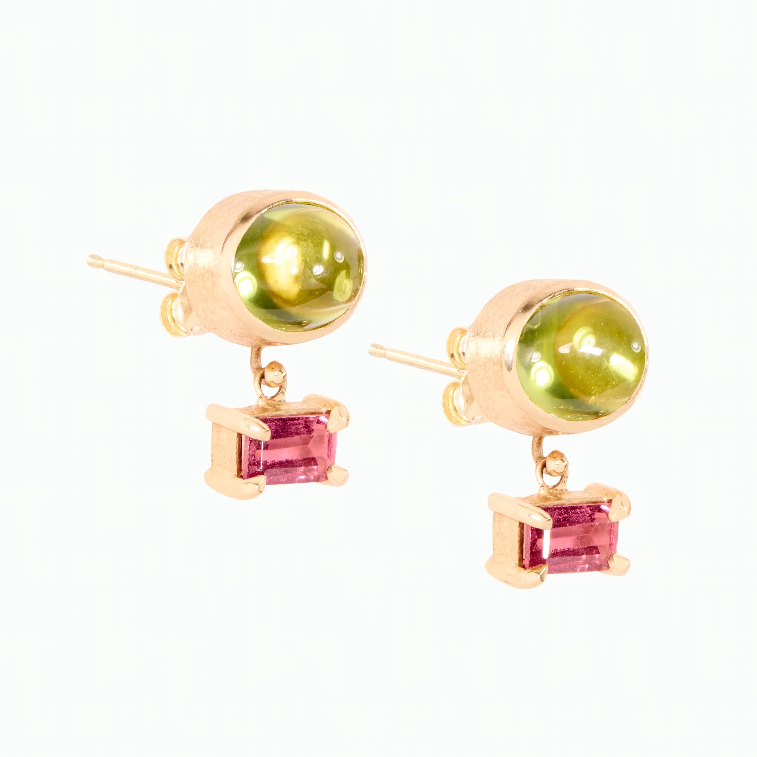 Gold earrings with green and purple gemstones on a white background
