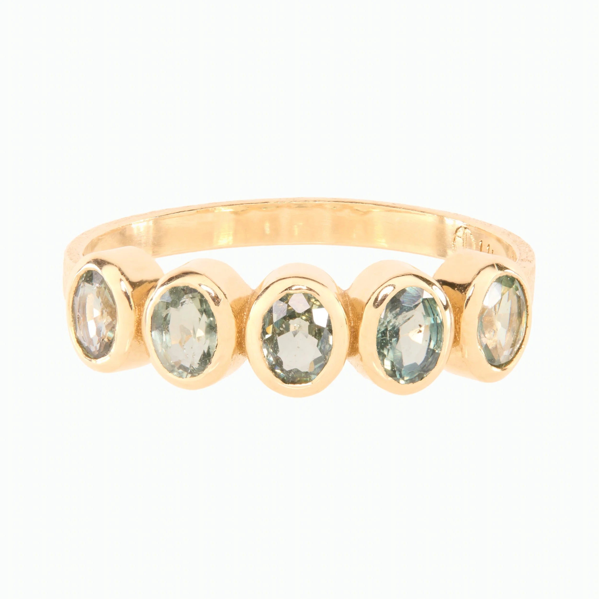 Gold ring with five green gemstones on a white background