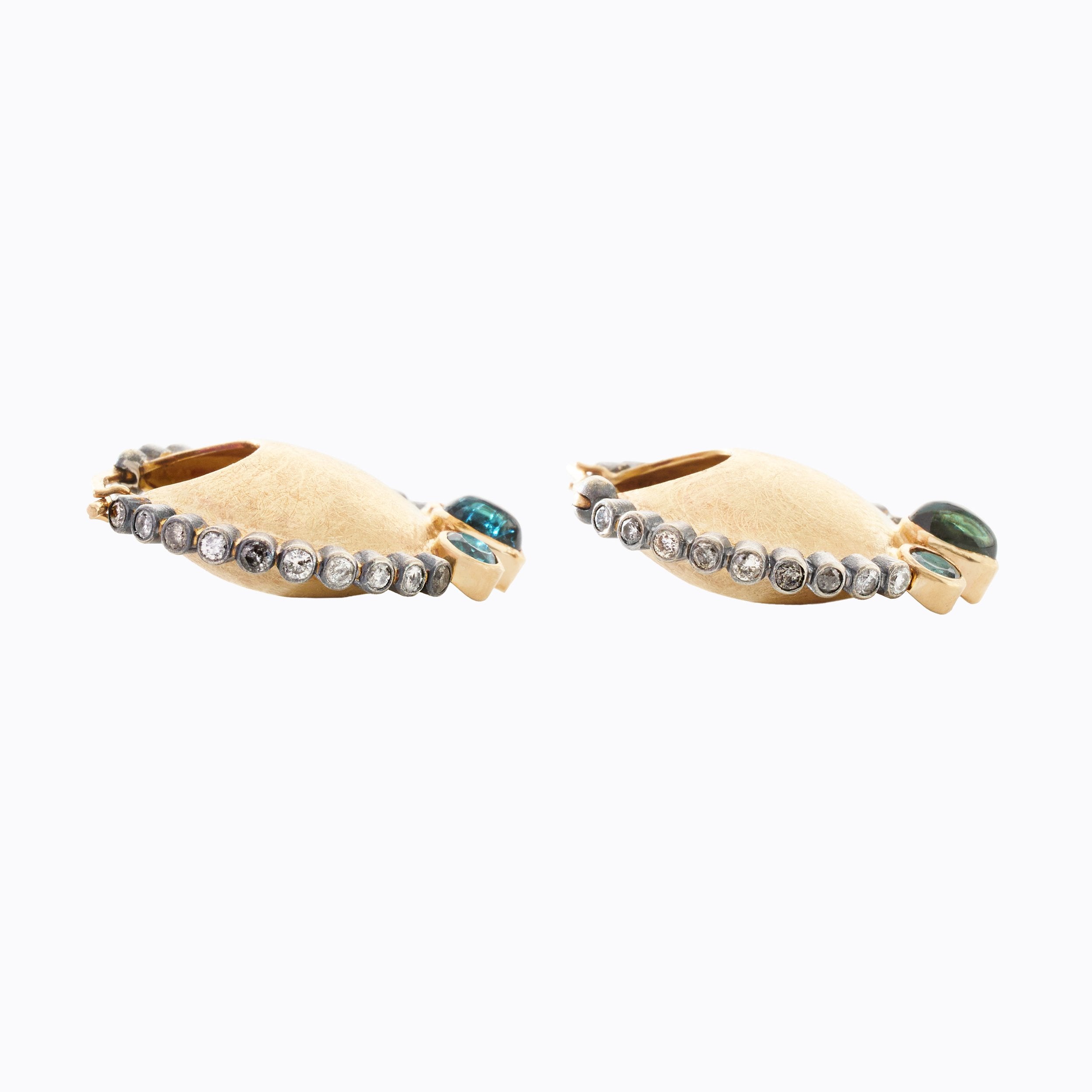 Pair of gold hoop earrings with gemstones on a white background