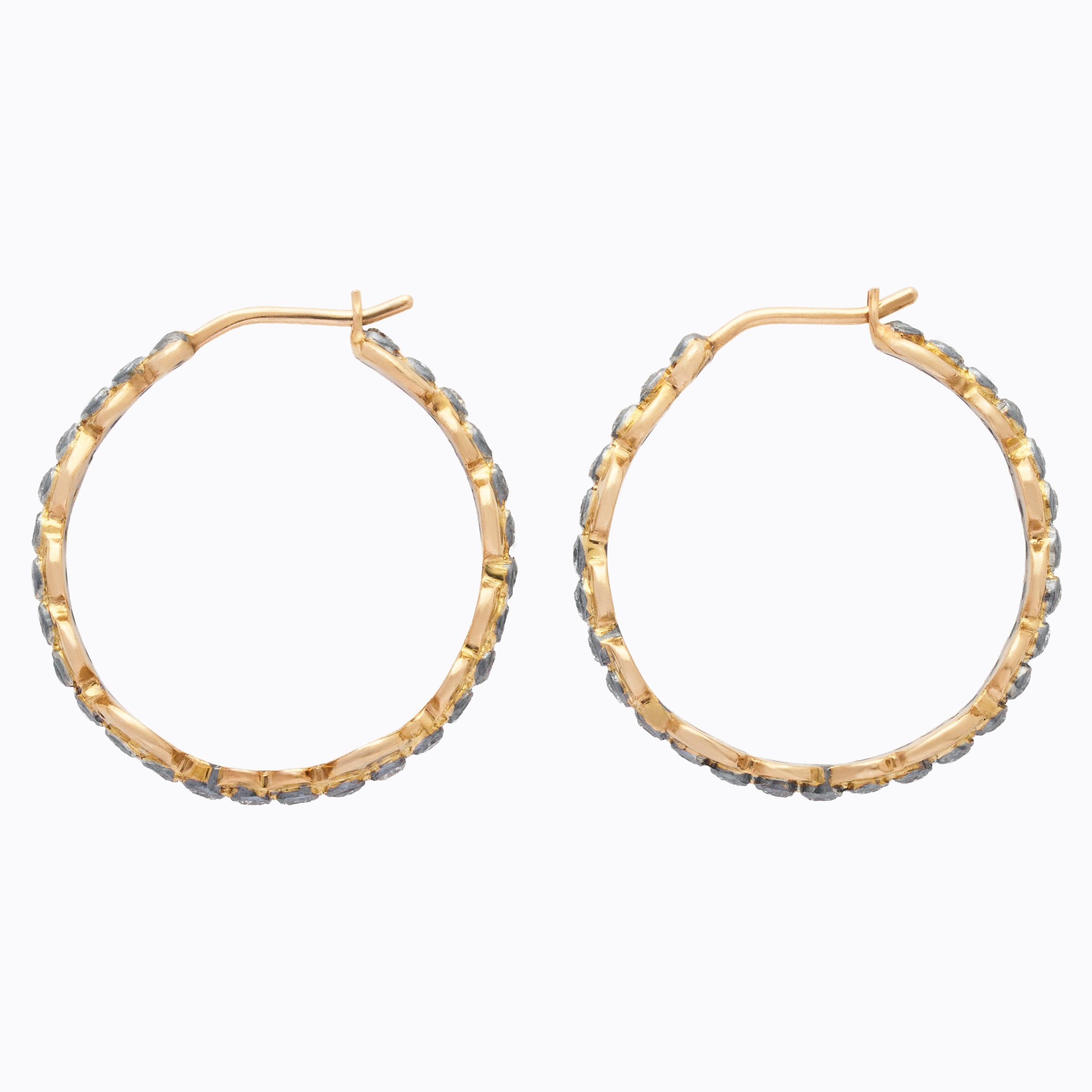 Gold hoop earrings with embedded stones on a white background