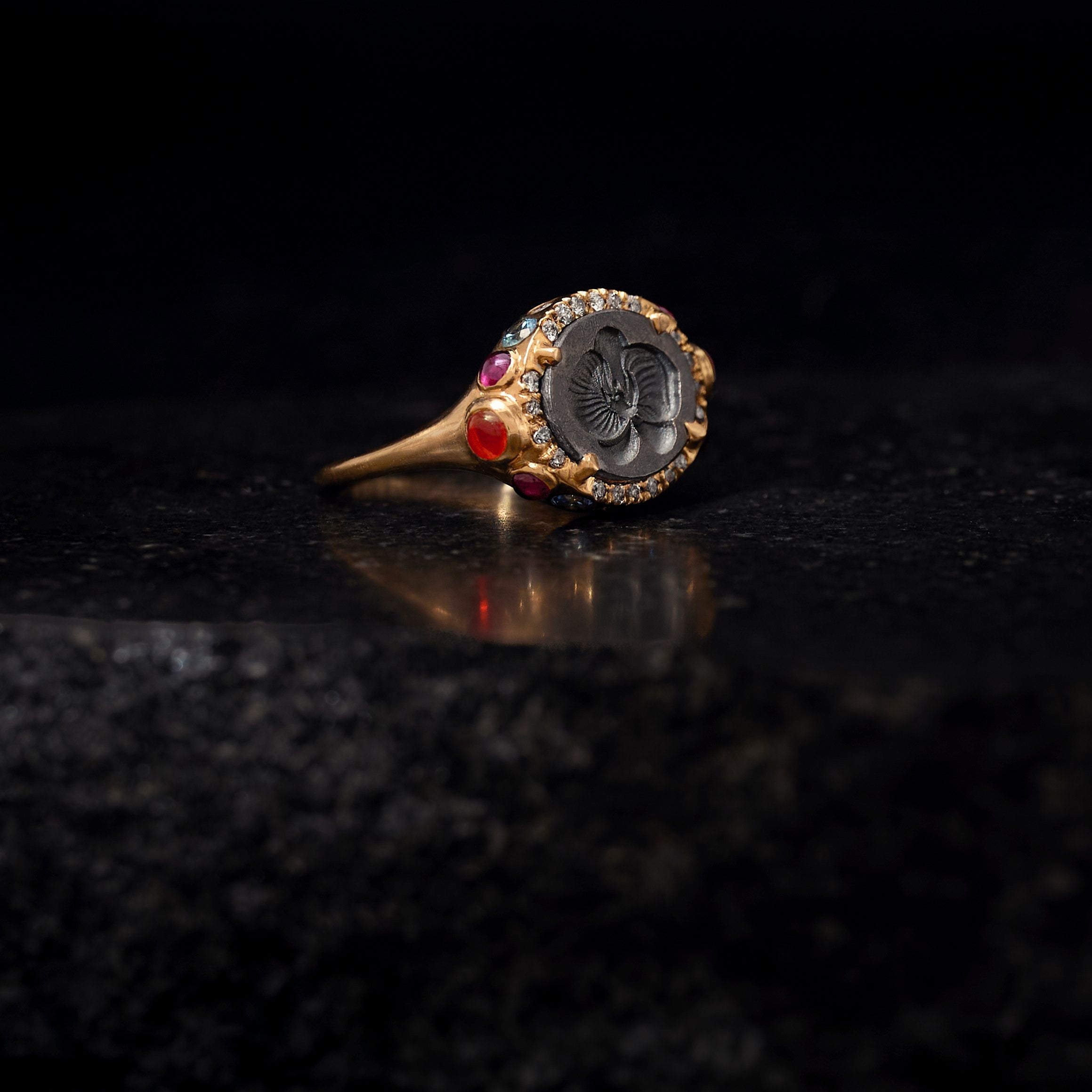 Gold ring with gemstones on a dark textured surface