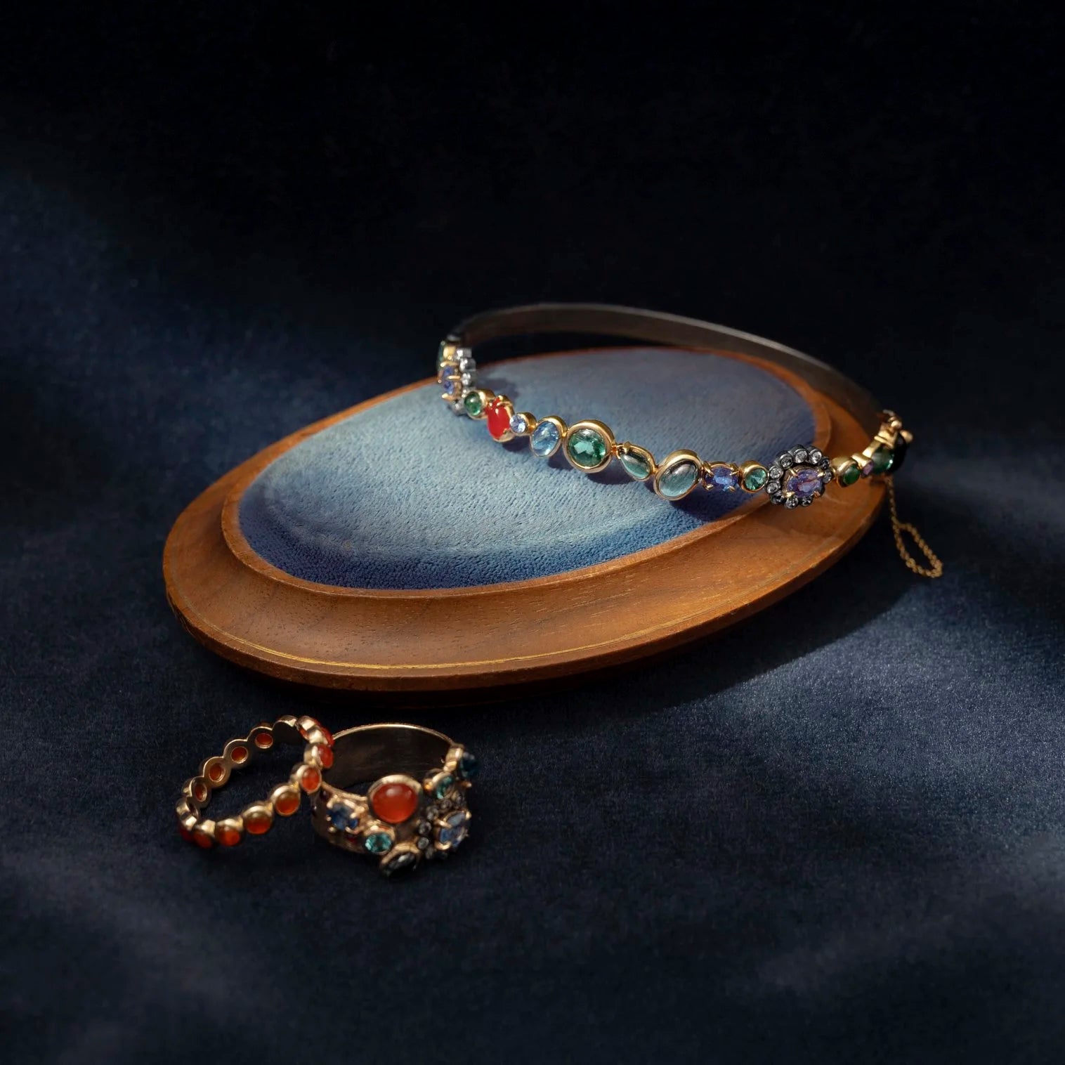 Decorative cuff bracelet with colorful gemstones on a dark background