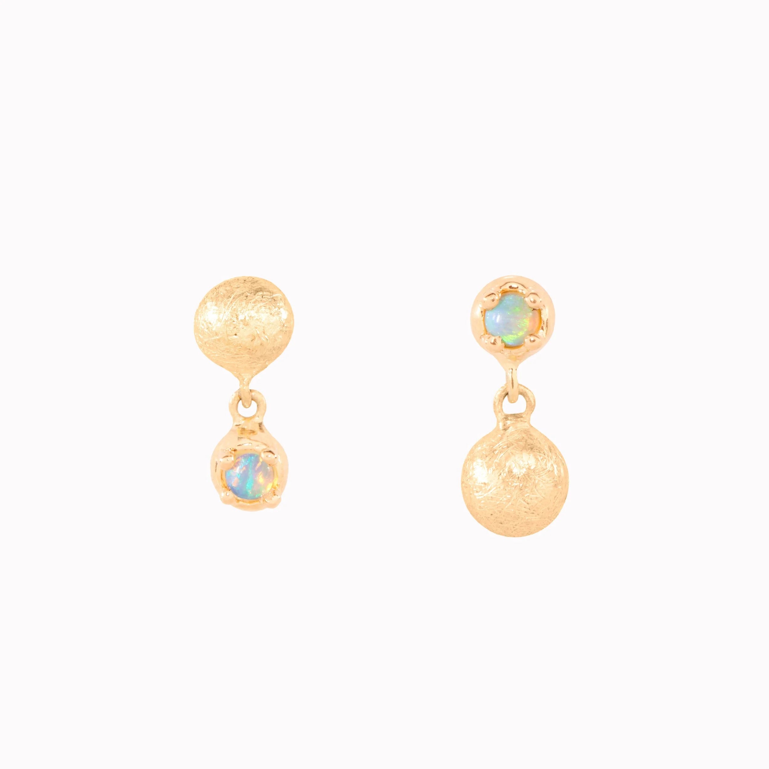 Gold earrings with opal stones on a white background