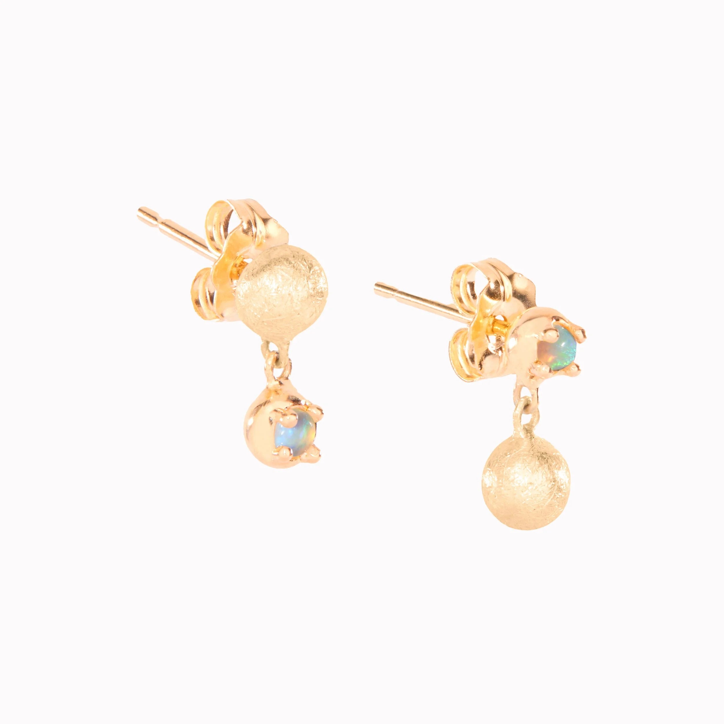 Gold earrings with spherical designs on a white background