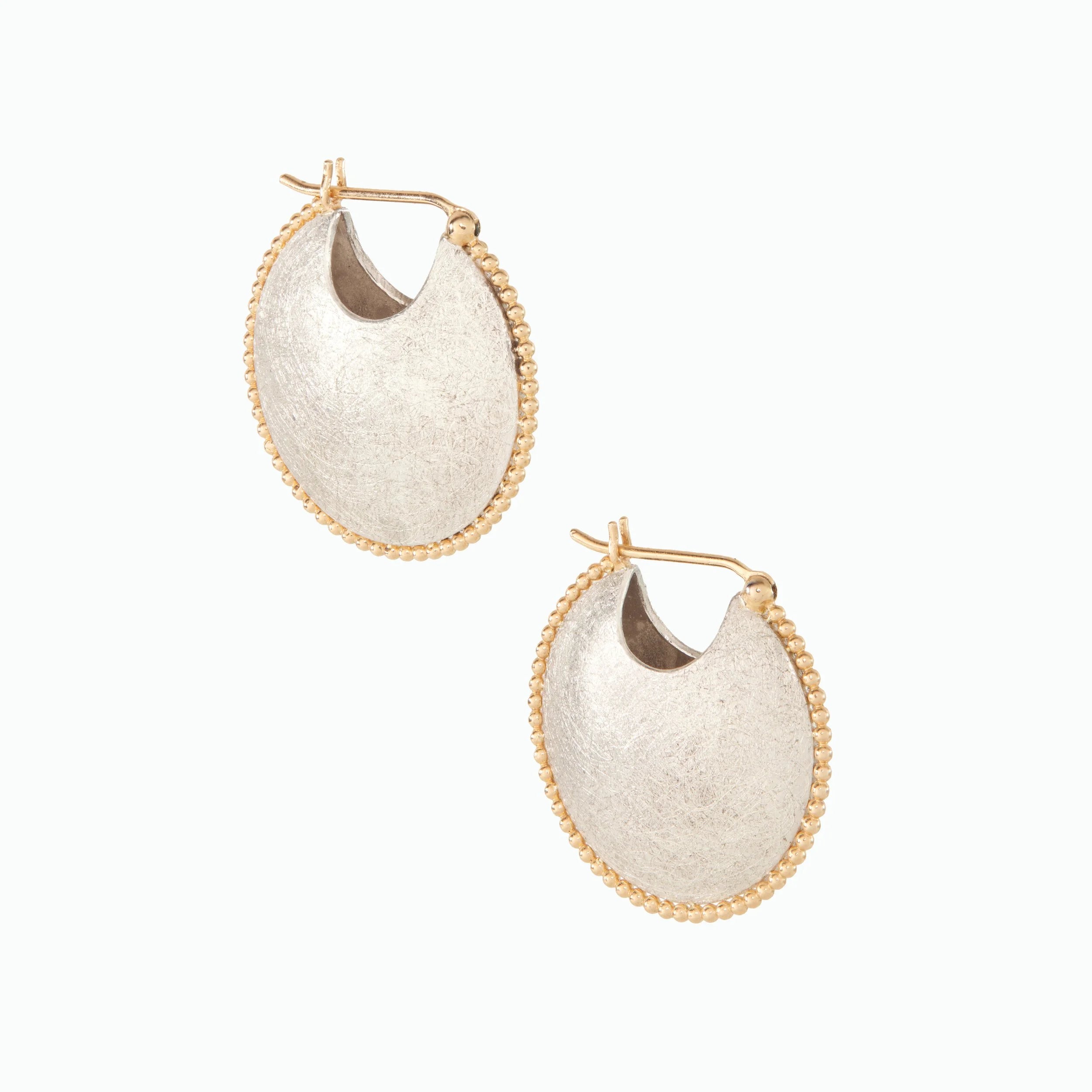 Pair of gold and silver hoop earrings with textured round ends on a white background