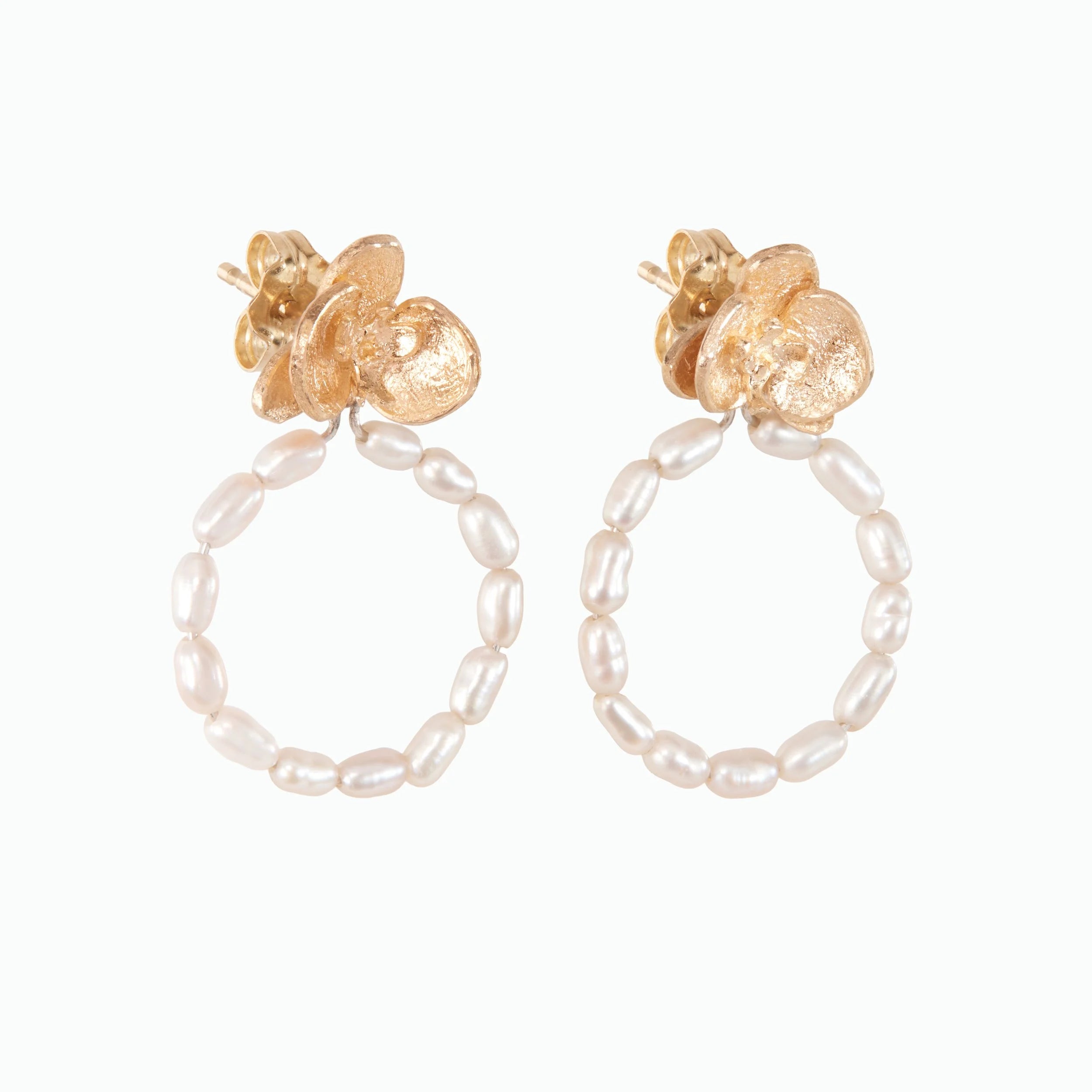 Pair of gold hoop earrings with pearl beads on a white background