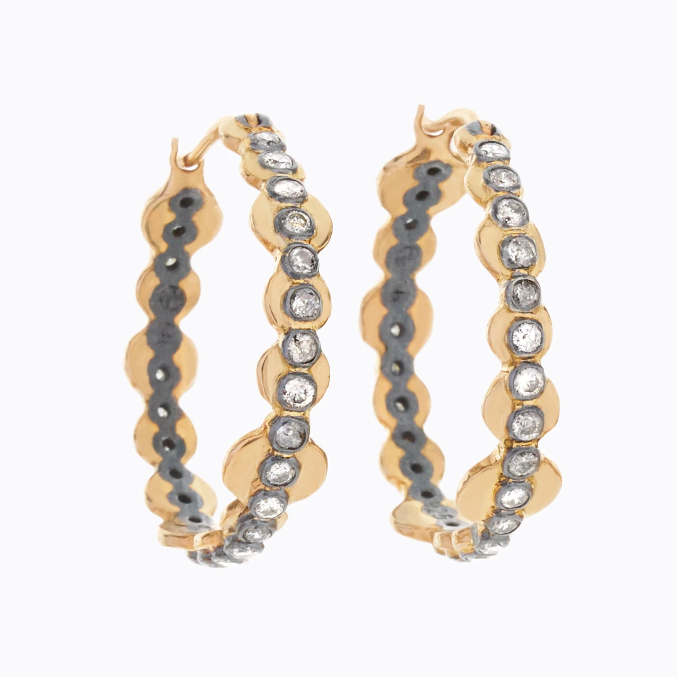 Gold hoop earrings with diamond stones on a white background
