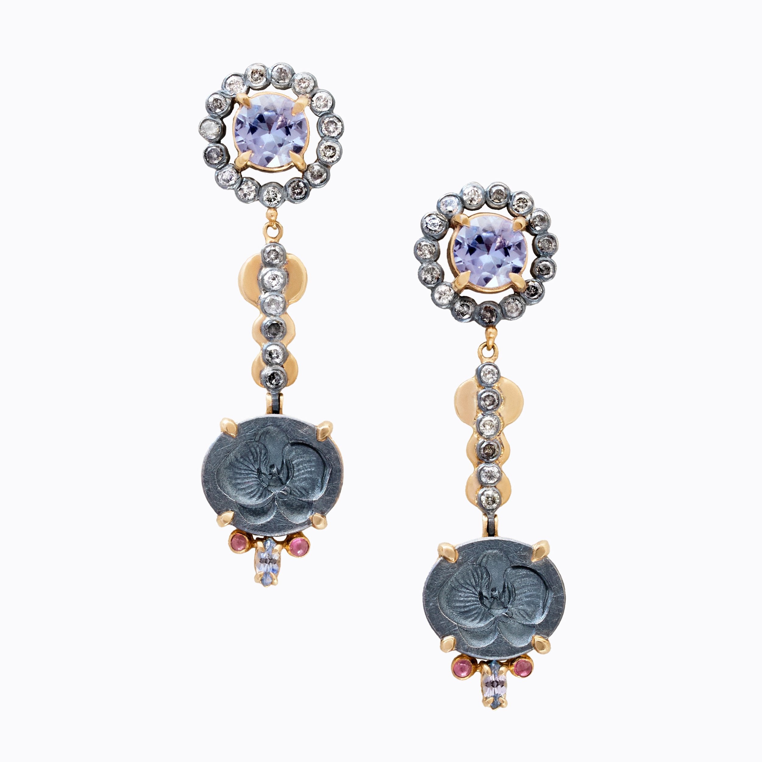 Pair of ornate earrings with gemstones on a white background