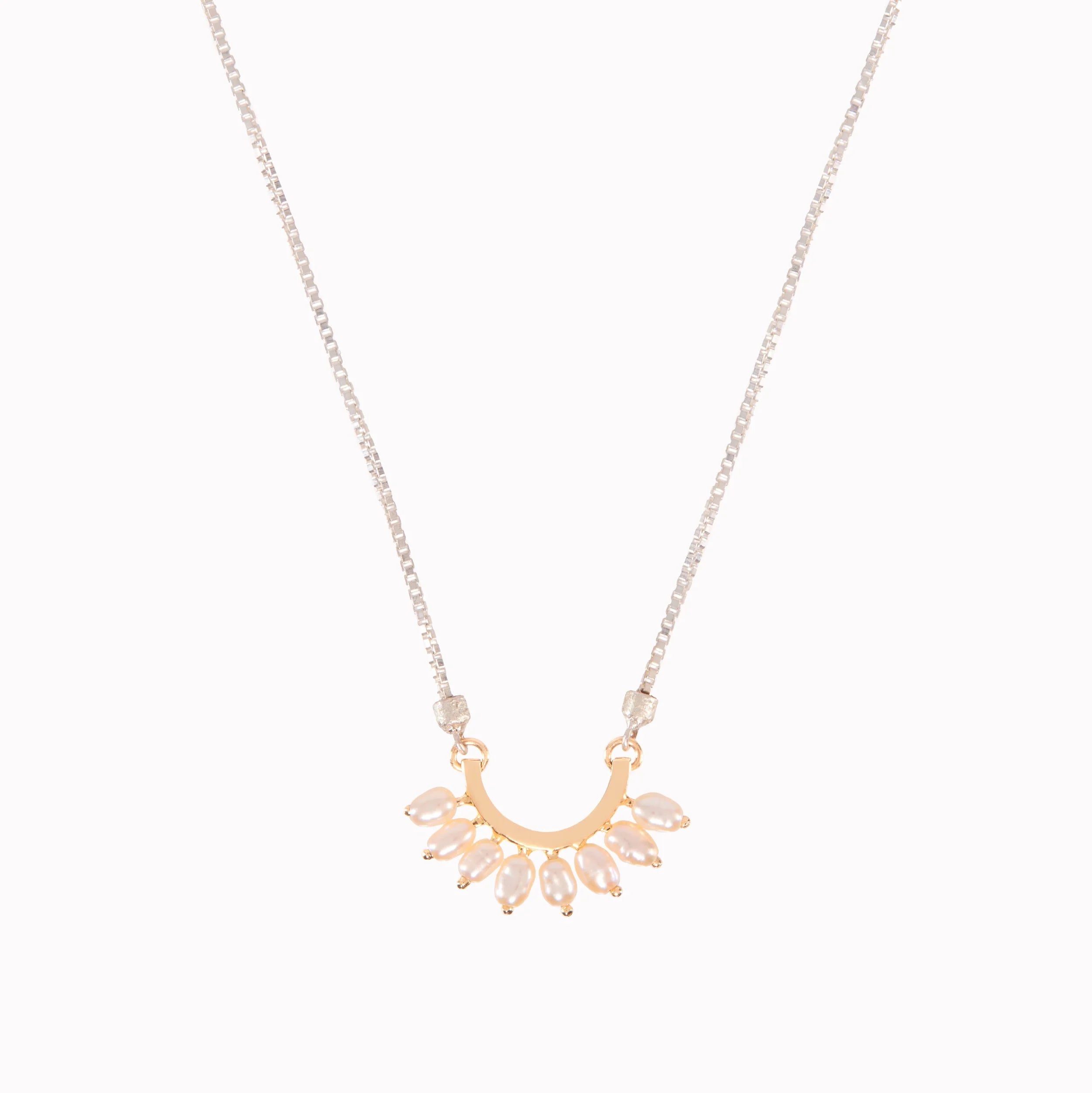 Gold necklace with a radial pearl pendant on a white background