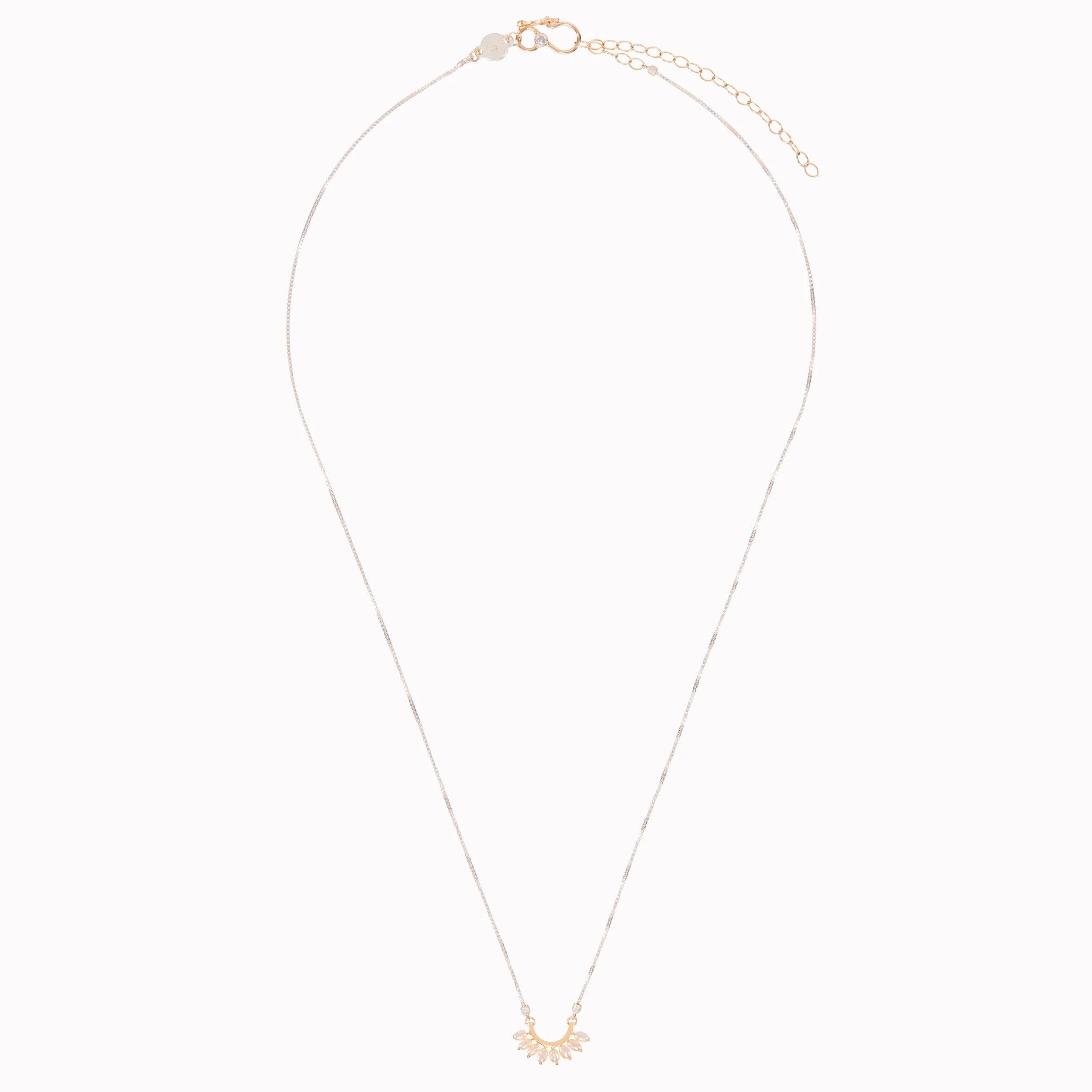 Gold necklace with a small pendant on a white background