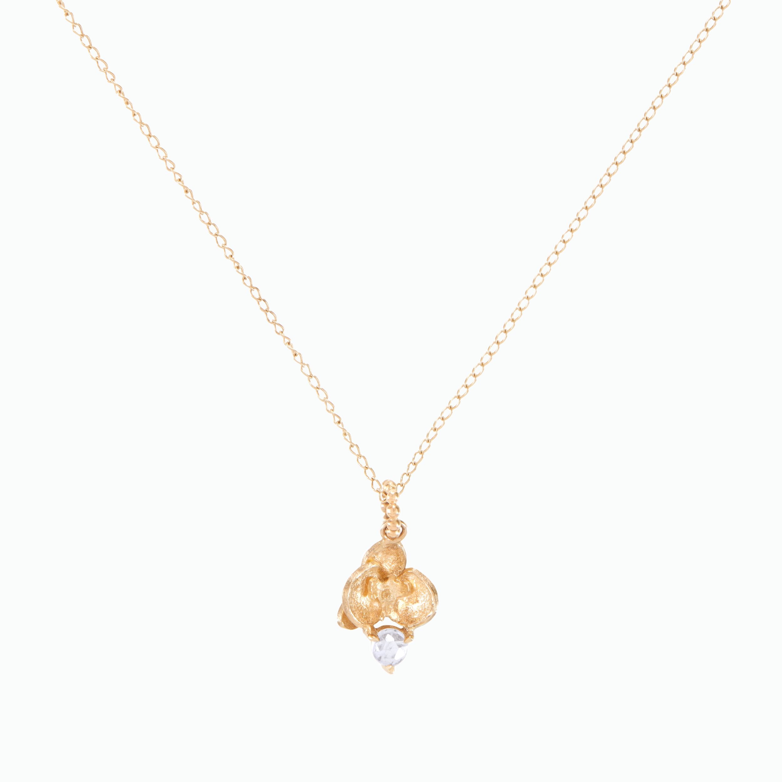 Gold necklace with a delicate pendant on a white background