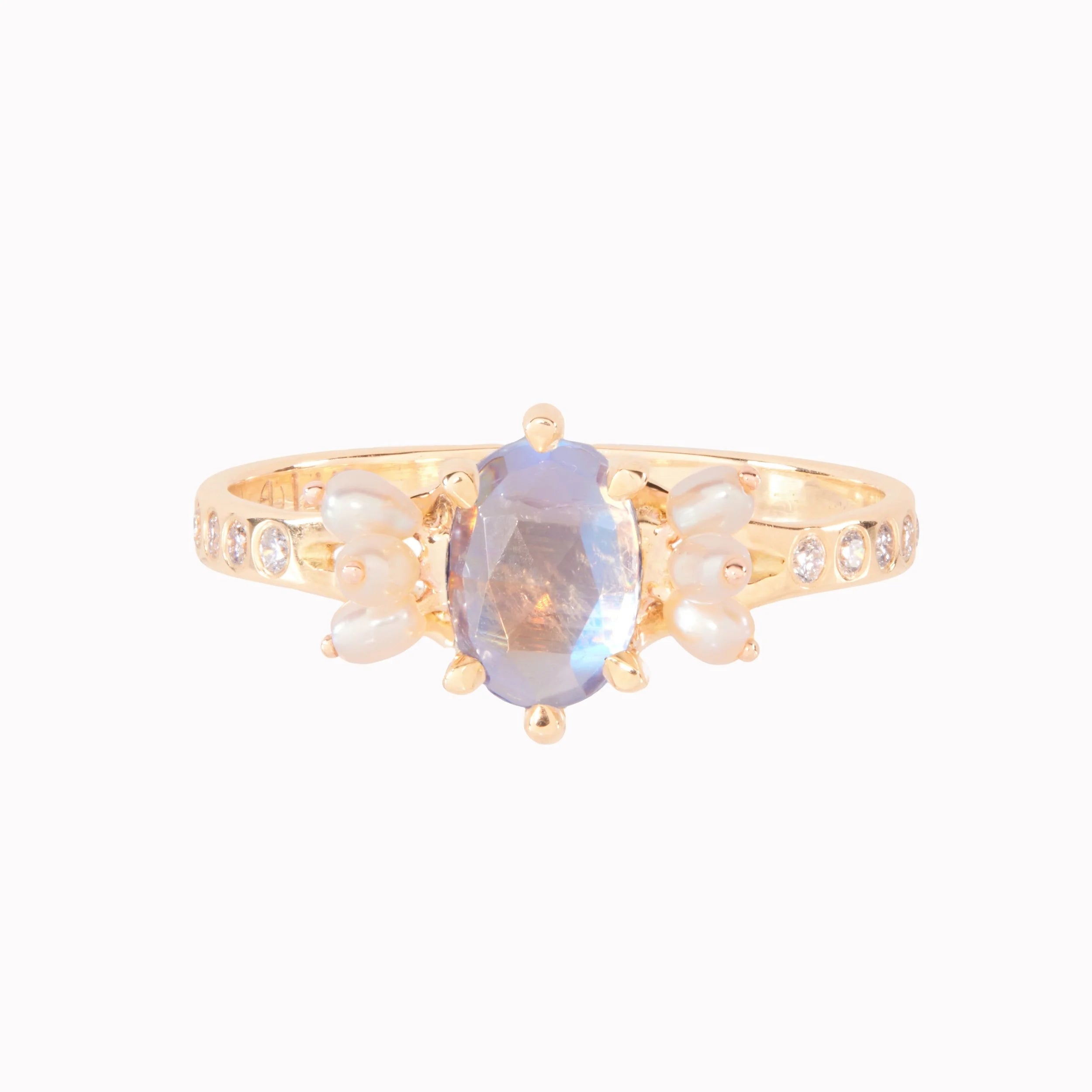 Gold ring with a central moonstone and pearl elements on a white background