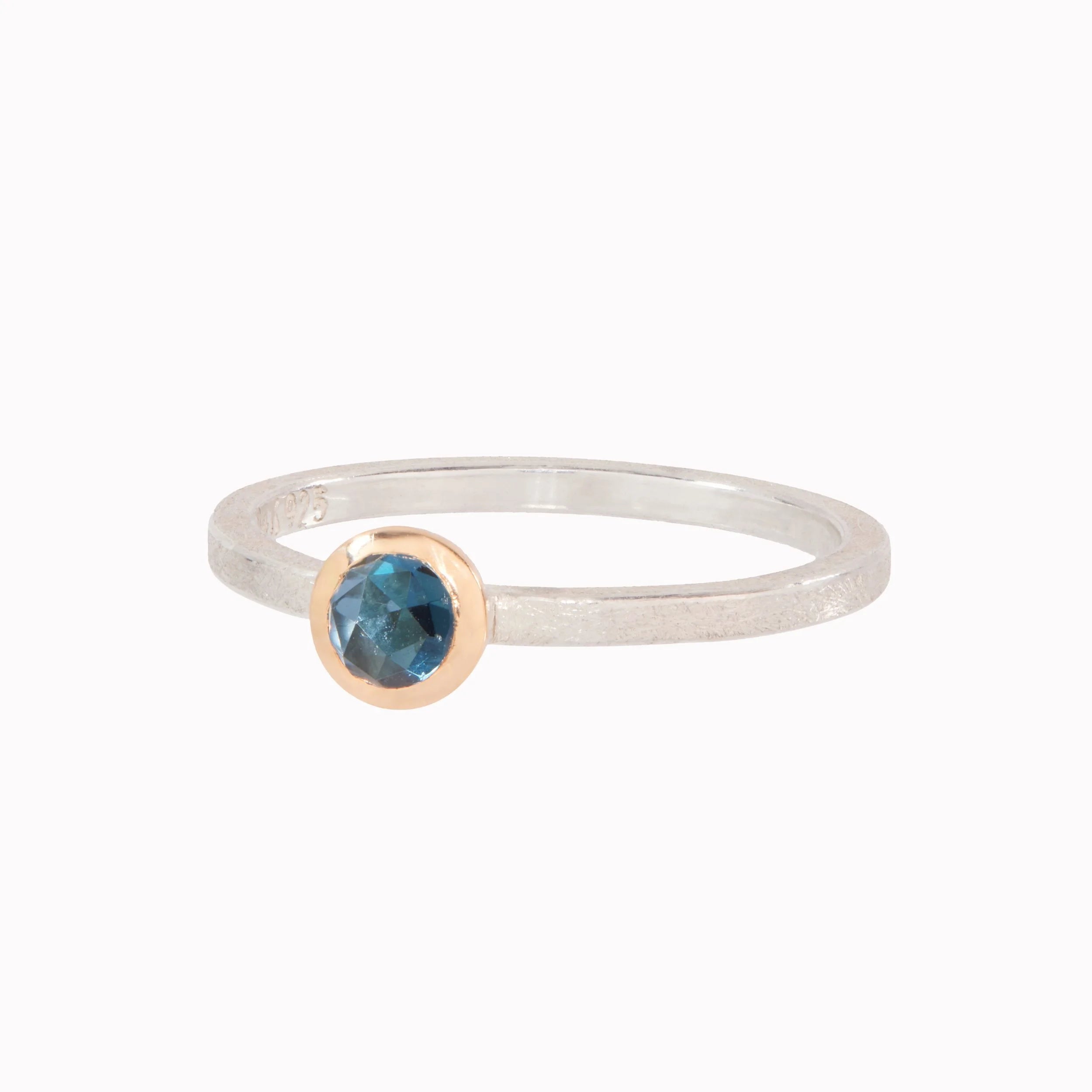 Ring with a blue gemstone on a white background