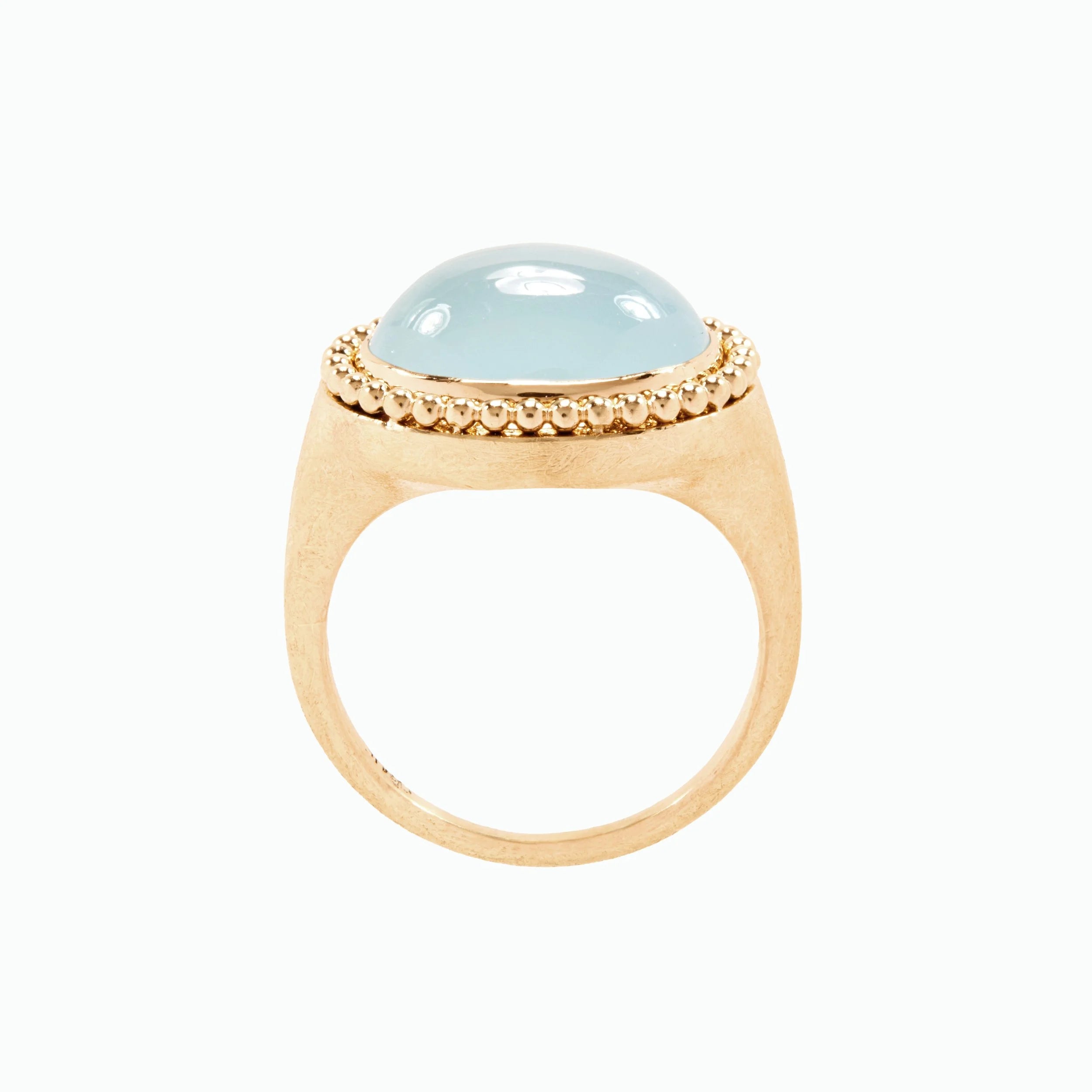 Gold ring with a light blue gemstone on a white background