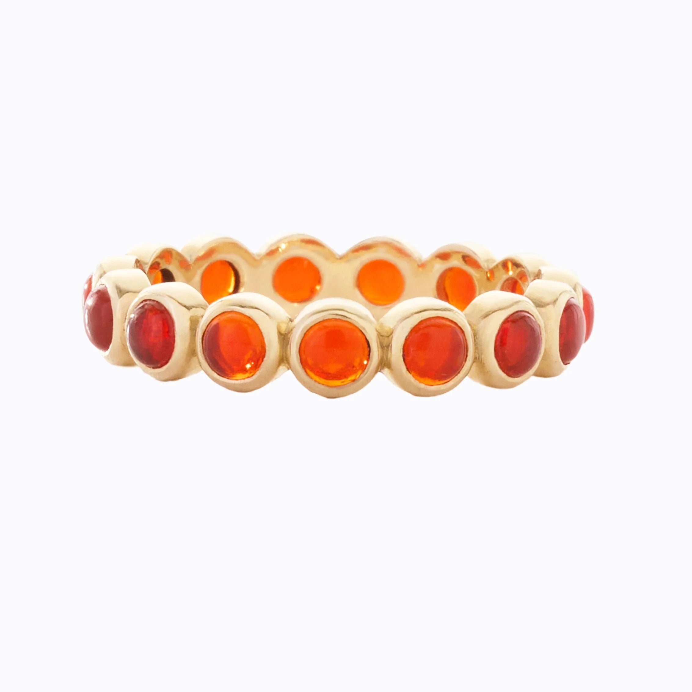 Gold ring with orange opal stones on a white background