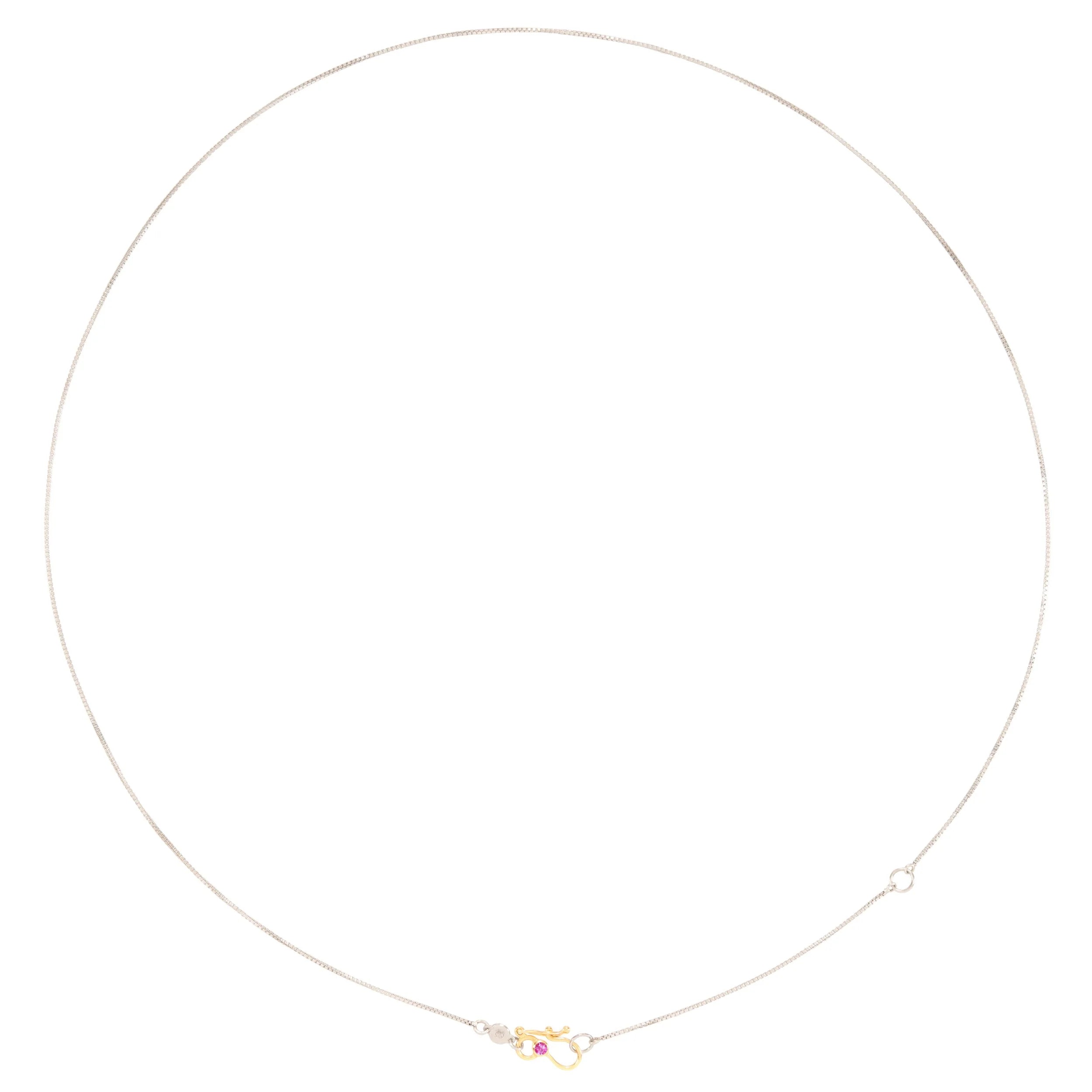 Thin silver necklace with a small pendant on a white background