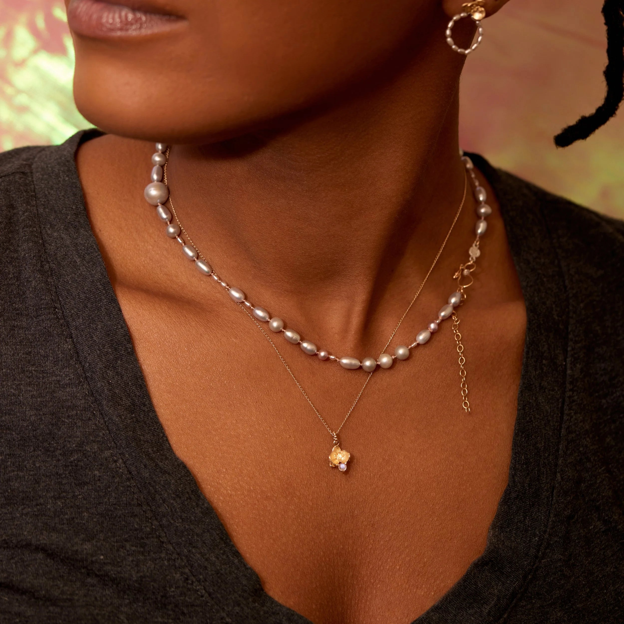 Close-up of a woman wearing pearl necklaces and earrings with a blurred background